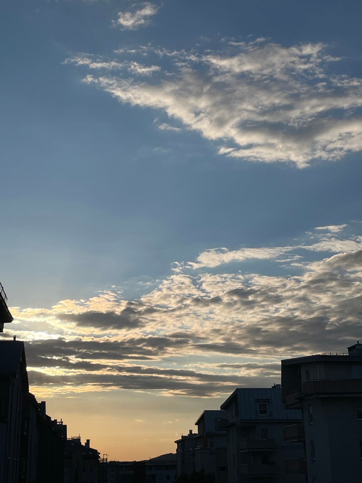 Urban sunset captured between buildings creates dramatic sky display