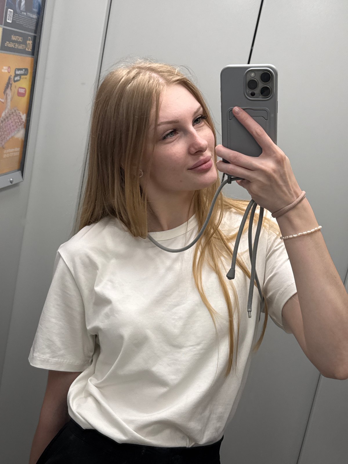 Mirror selfie in a Perm elevator, grey phone in hand.