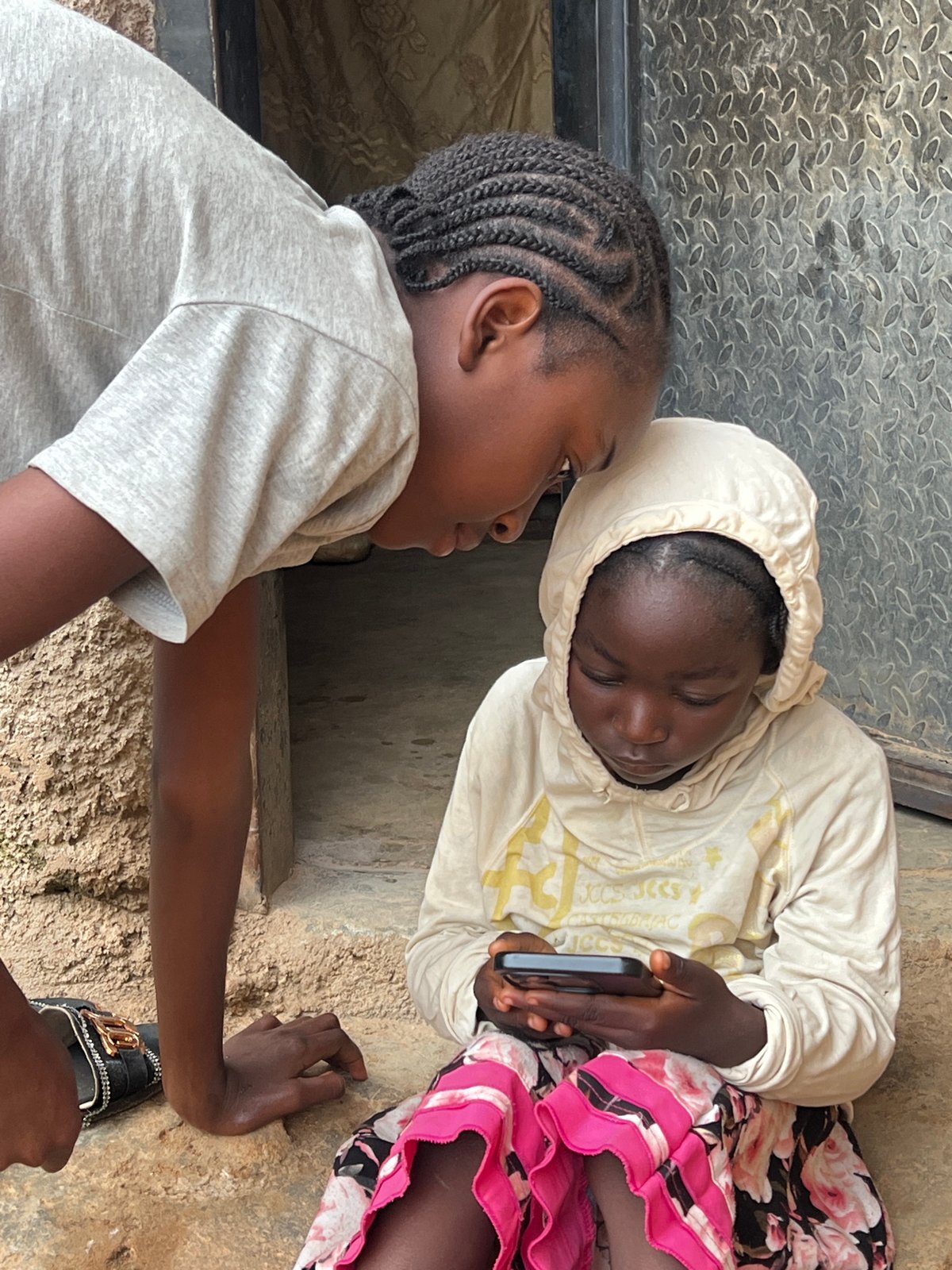 Sharing a phone screen outside in Jos, Nigeria