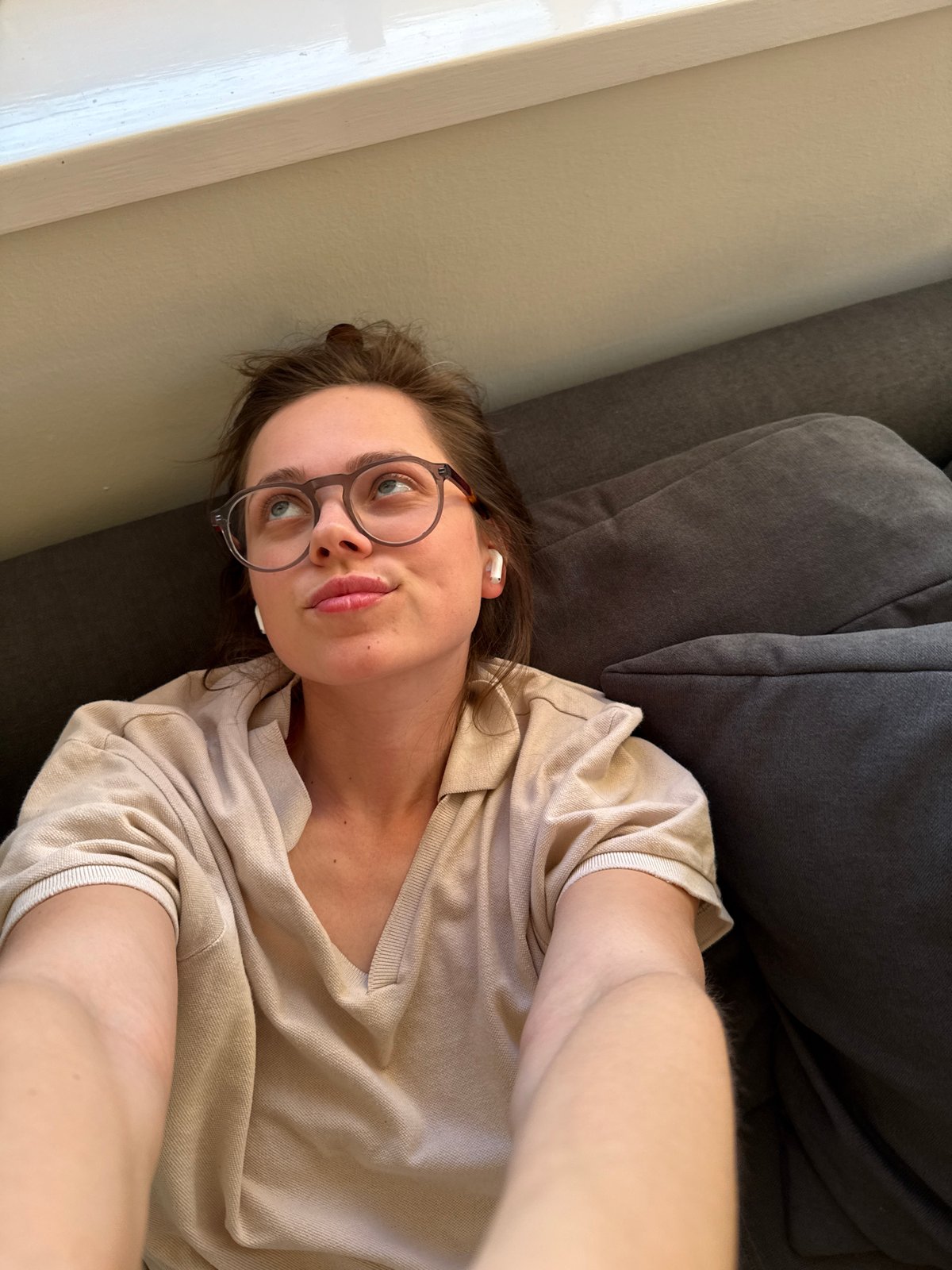 Woman takes casual selfies on couch in Budapest home