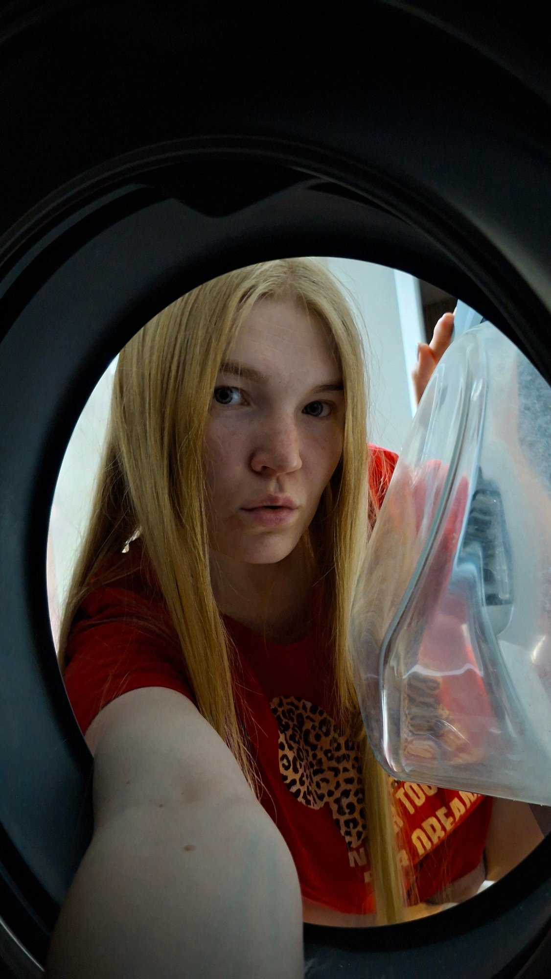 Woman documents casual evening with books, cat, washing machine