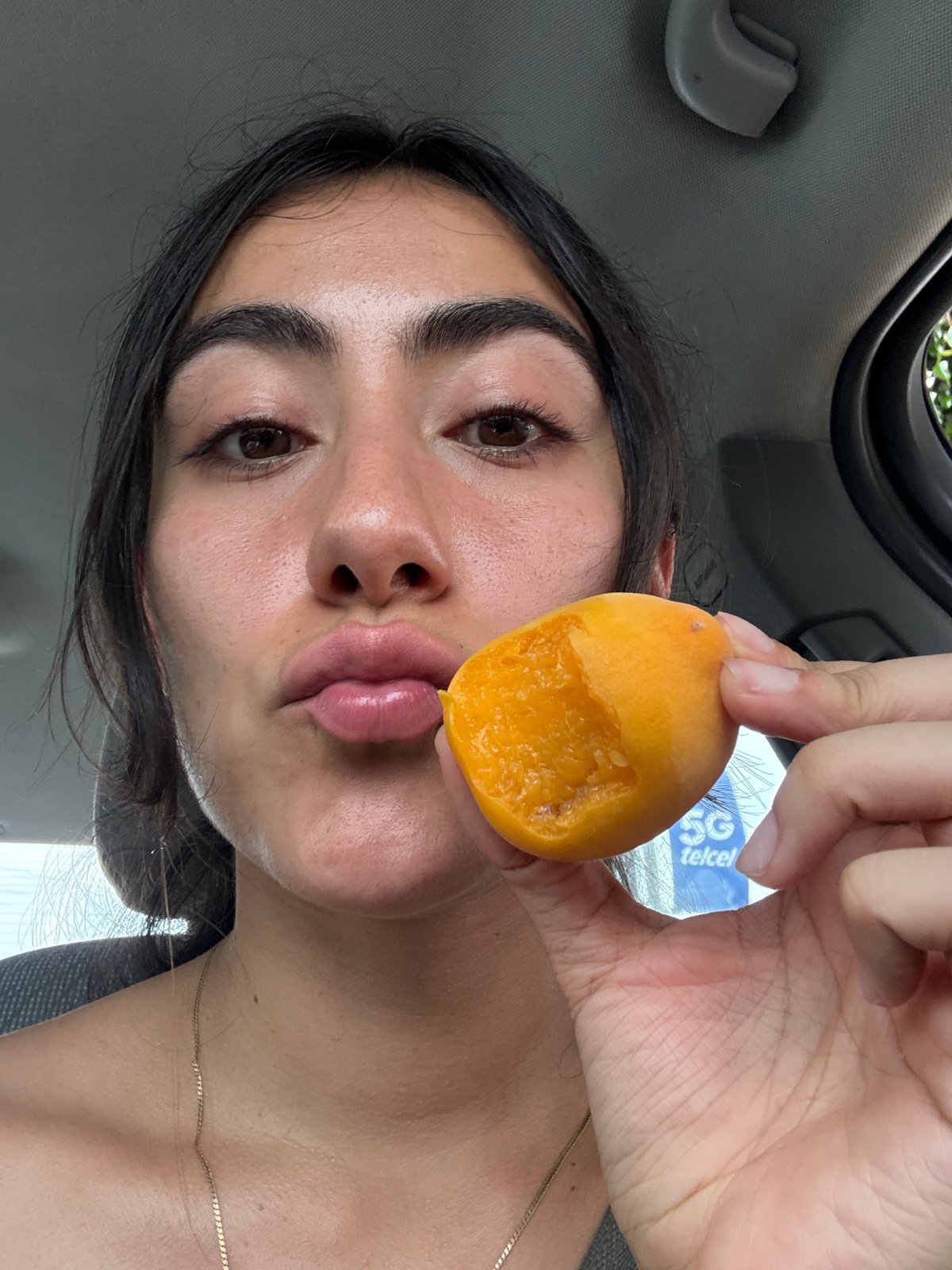 Woman eats apricot in car in Puebla, Mexico