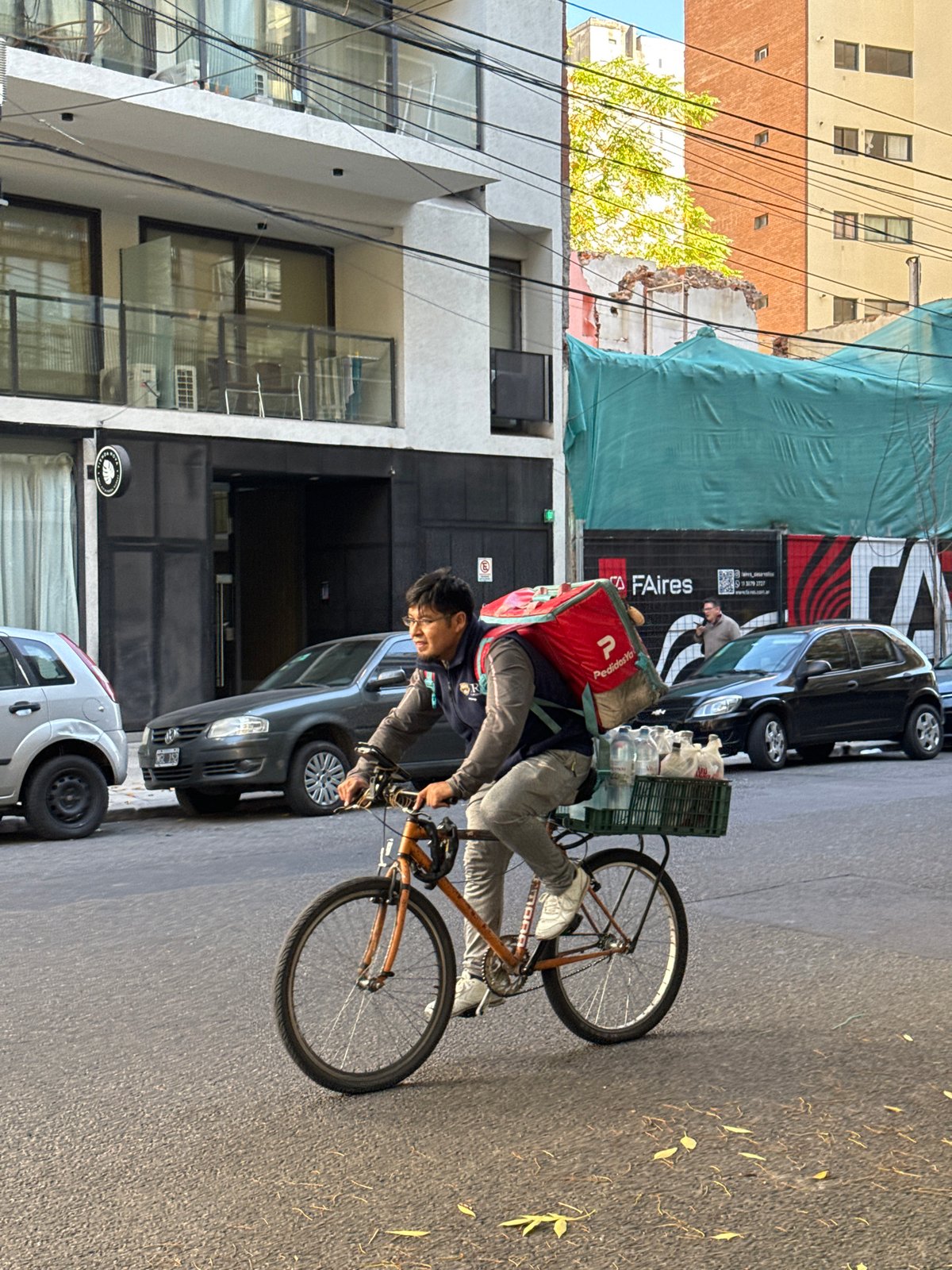 Delivery worker cycles through Buenos Aires street scene