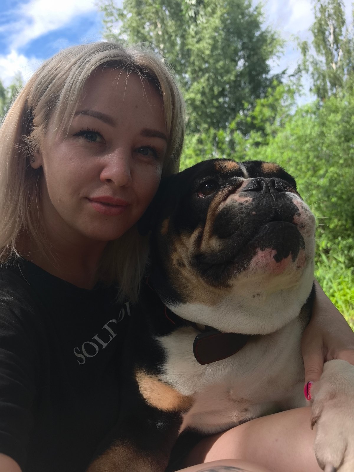 Woman poses with peonies and bulldog in Noviy