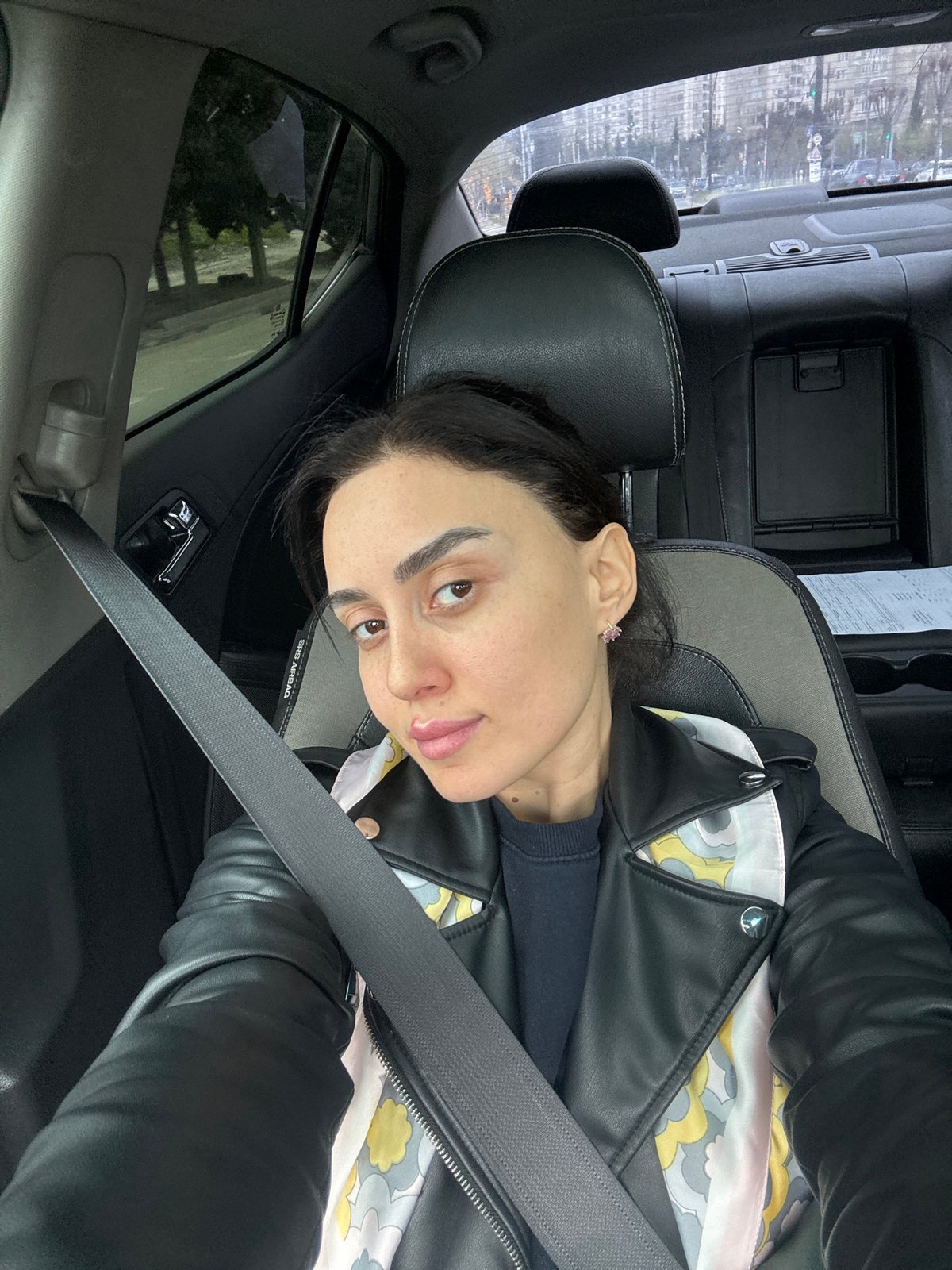 Woman takes selfie in car in urban Tbilisi
