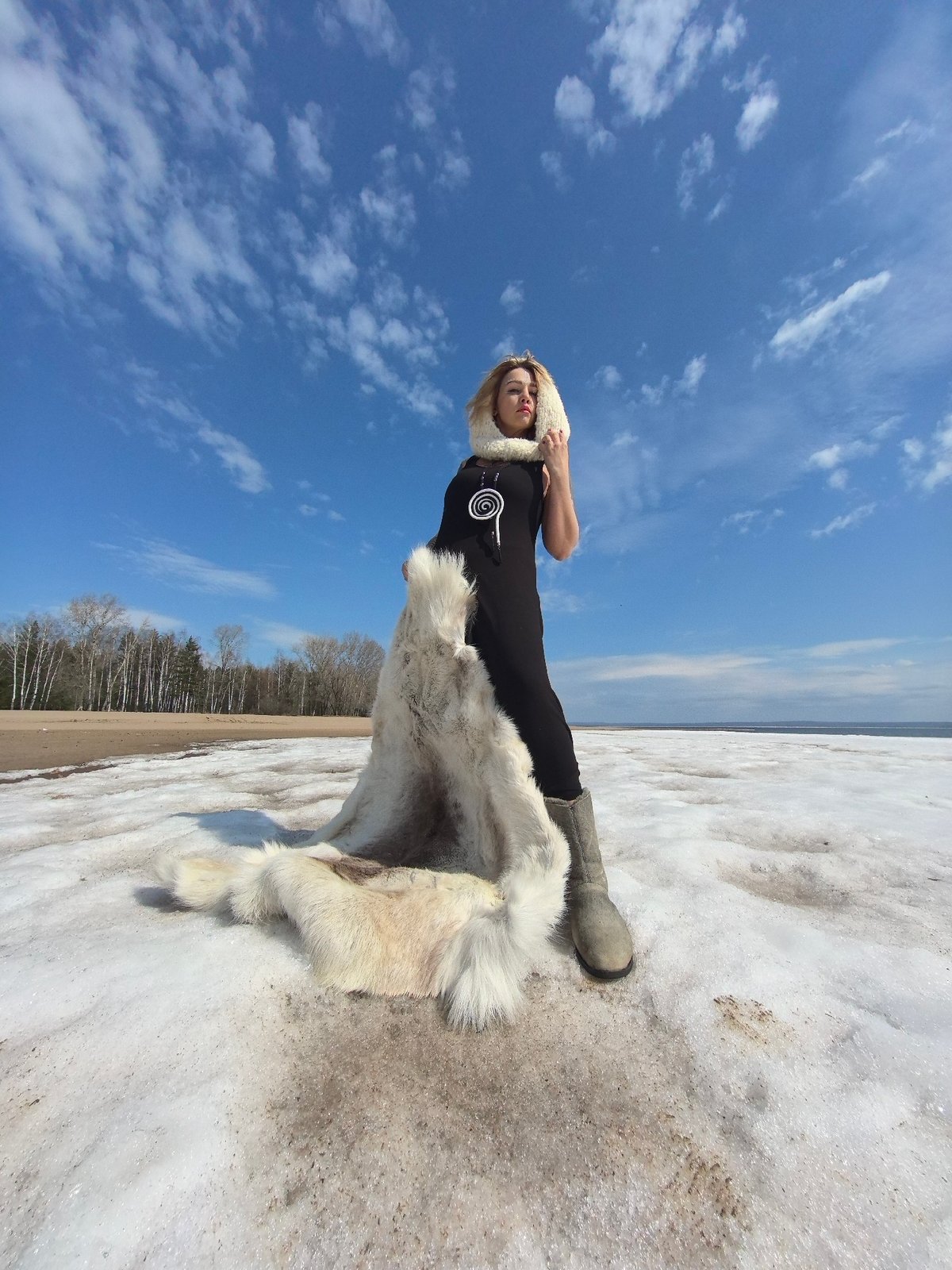 Woman poses in melting snow landscape in Noviy, Russia