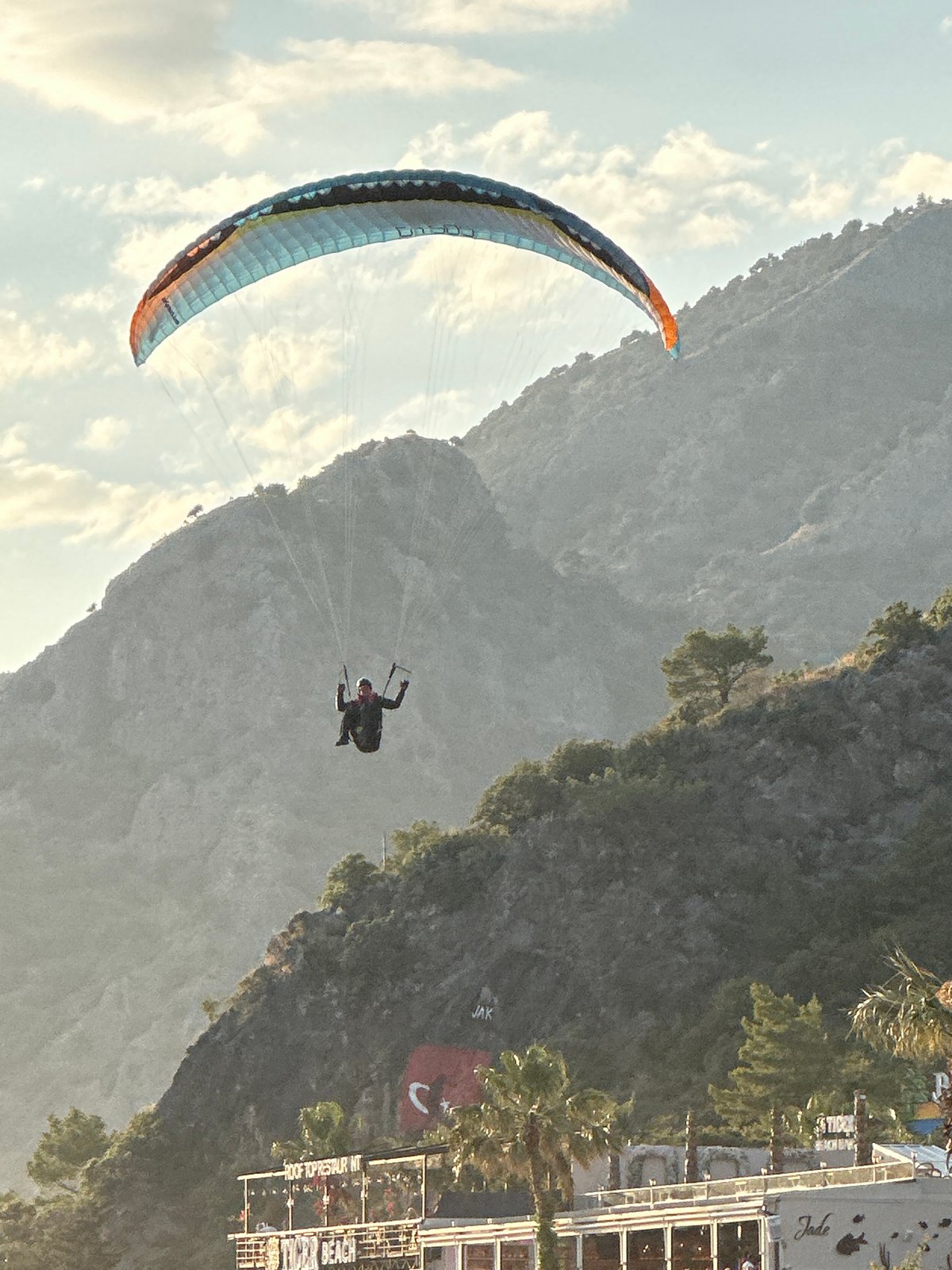 Paragliders active over crowded Fethiye boardwalks, Turkey