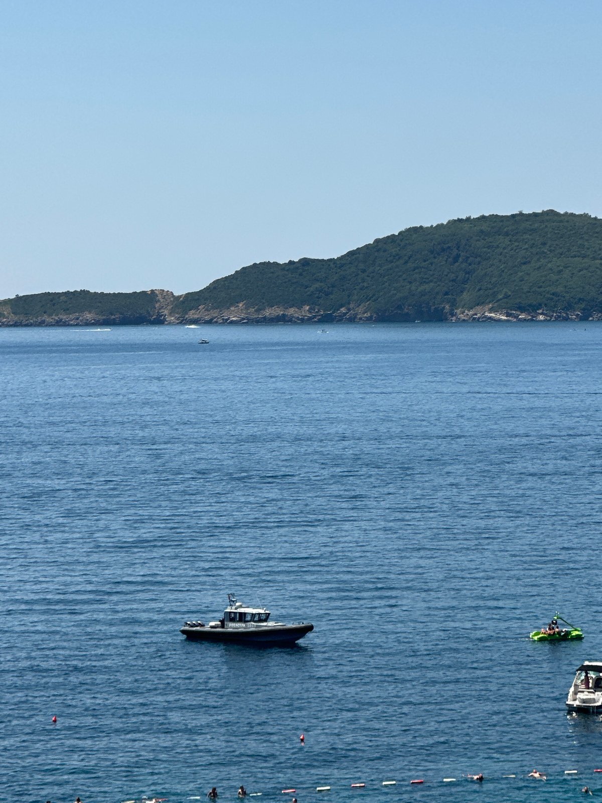 Crowded beach day at Kamenovo with parasailing over the Adriatic