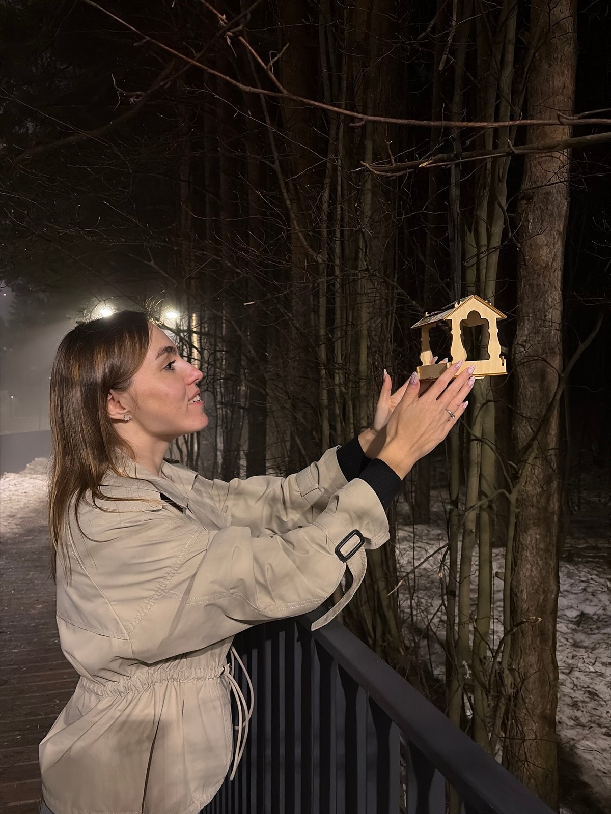 Woman poses on bridge during foggy evening in Izhevsk