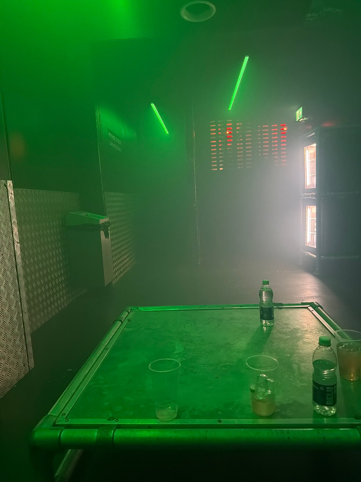 Green-lit backstage area captured at London performance venue