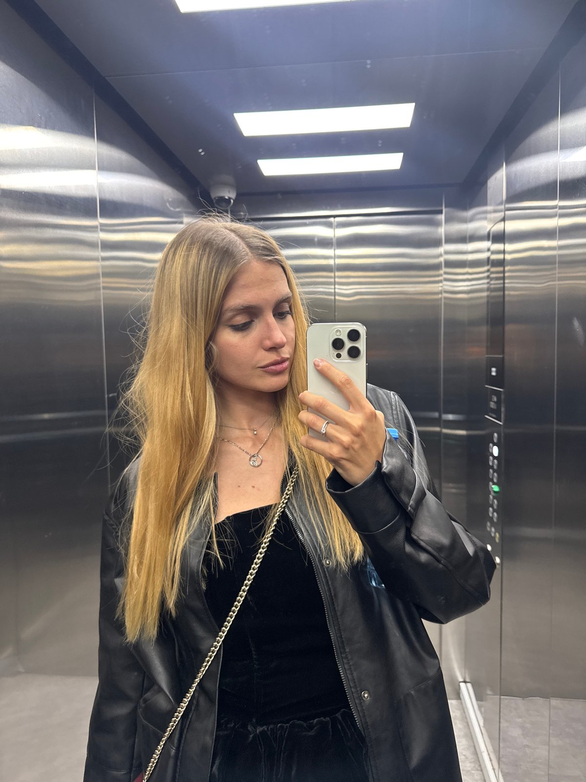 Woman Takes Selfie in Elevator While Wearing Black Leather