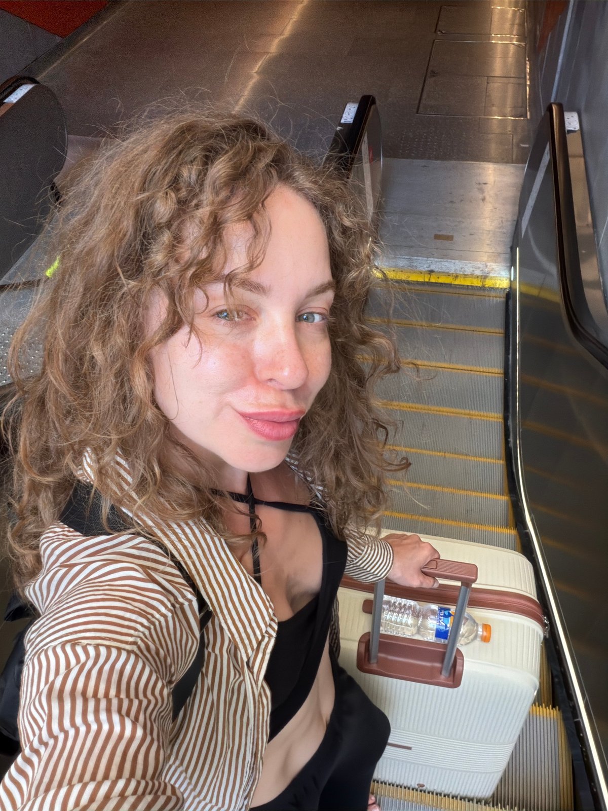 Selfie on escalator with luggage in Tel Aviv