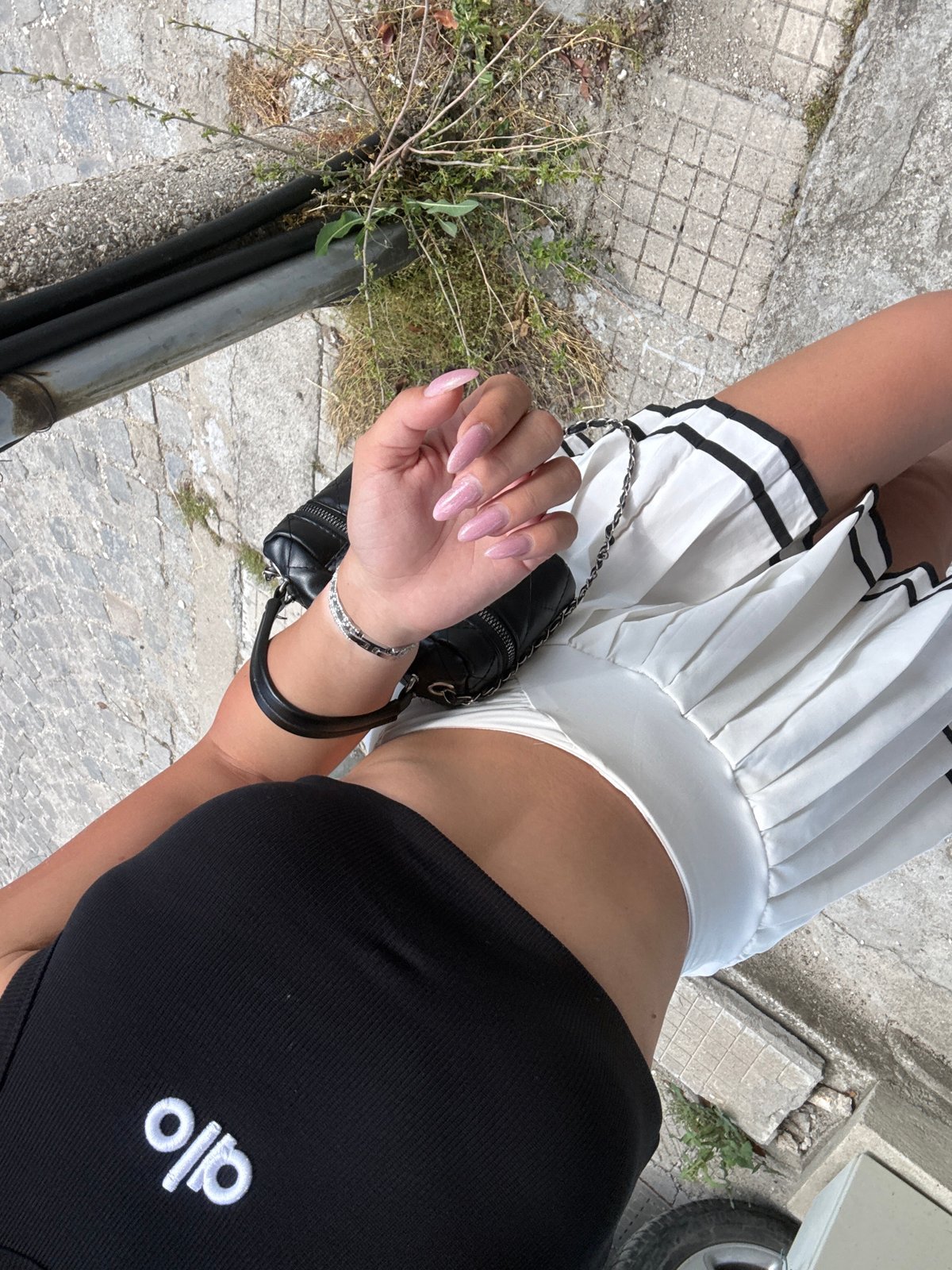 Woman in Alo outfit photographed taking selfies outdoors