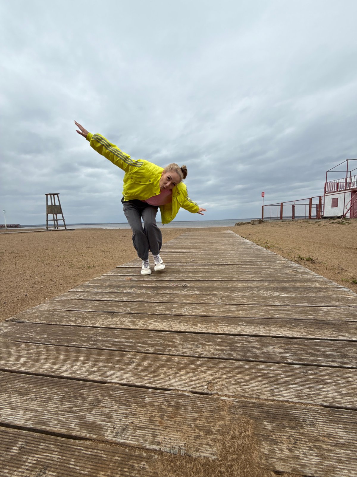 Woman poses playfully on boardwalk in Chaykovsky, Russia