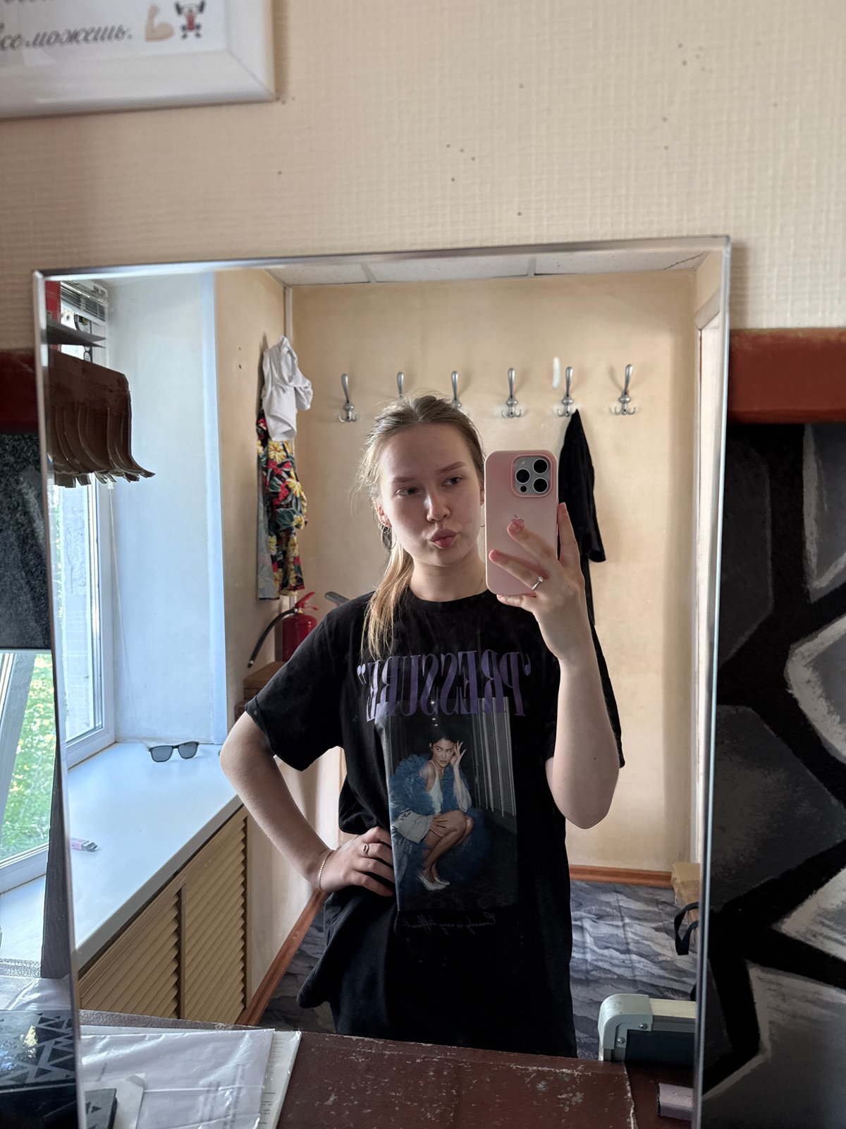 Woman takes mirror selfie with pink phone in Chaikovsky