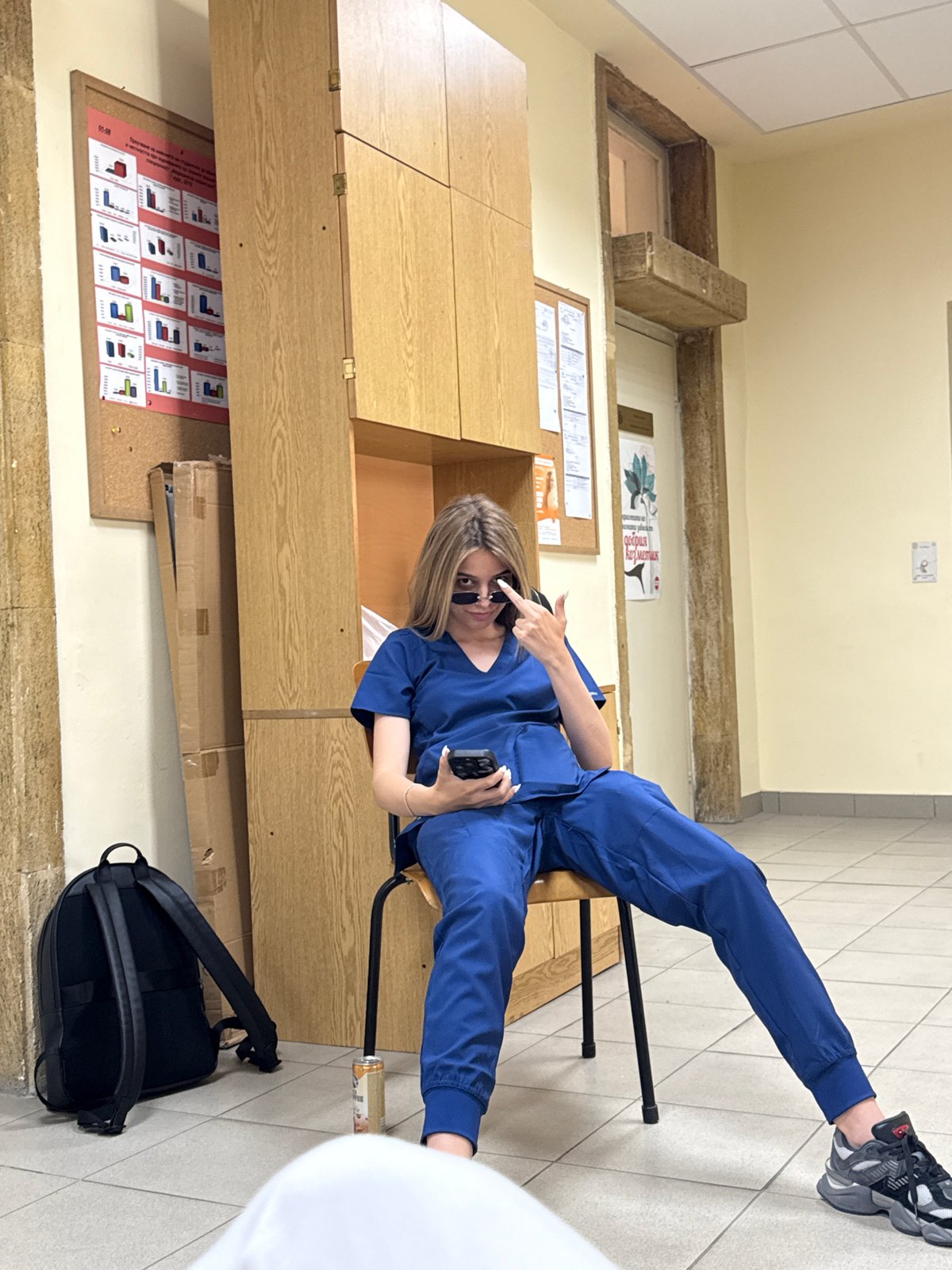 Medical worker in scrubs takes phone break in Pleven