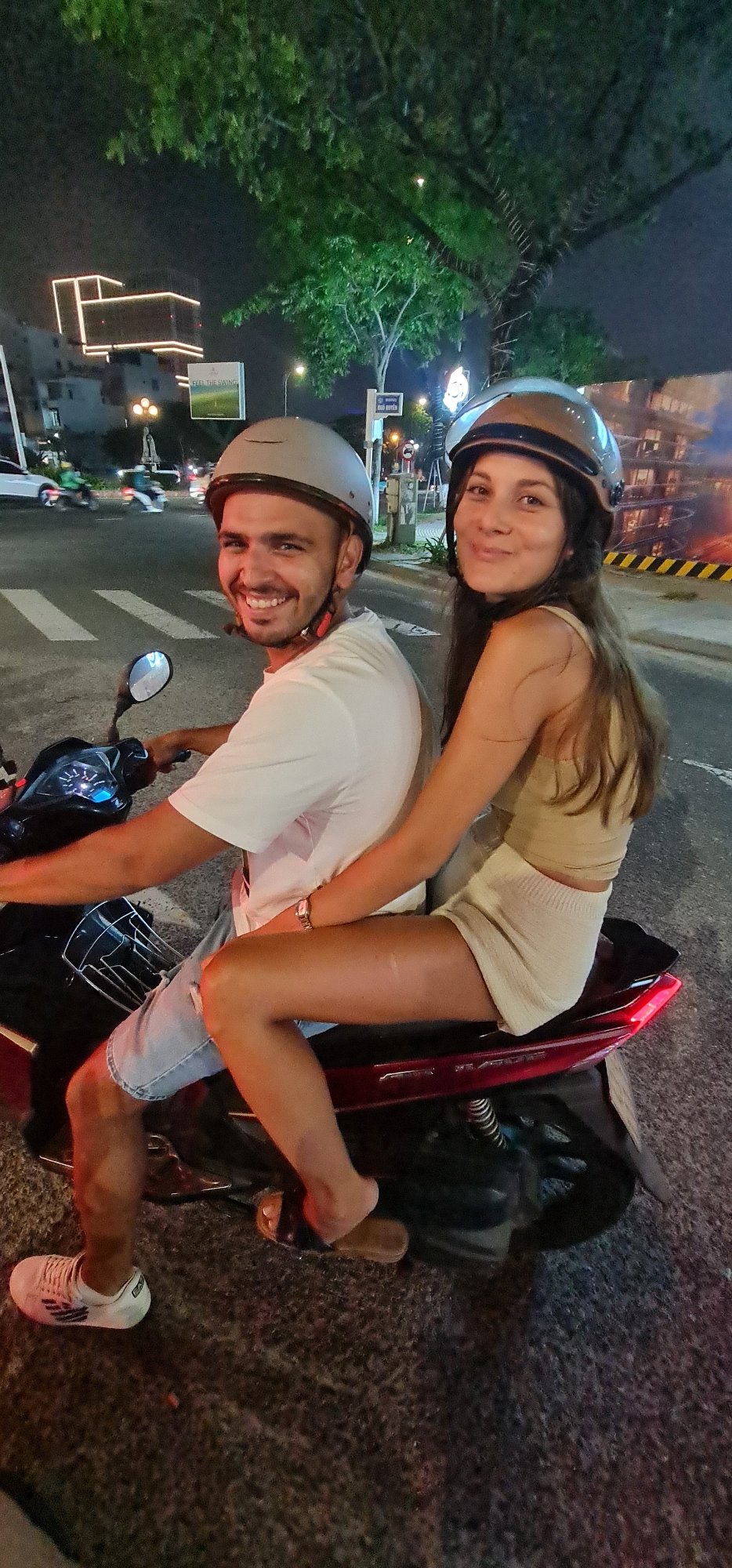 Families ride motorcycles through Đà Nẵng streets at night