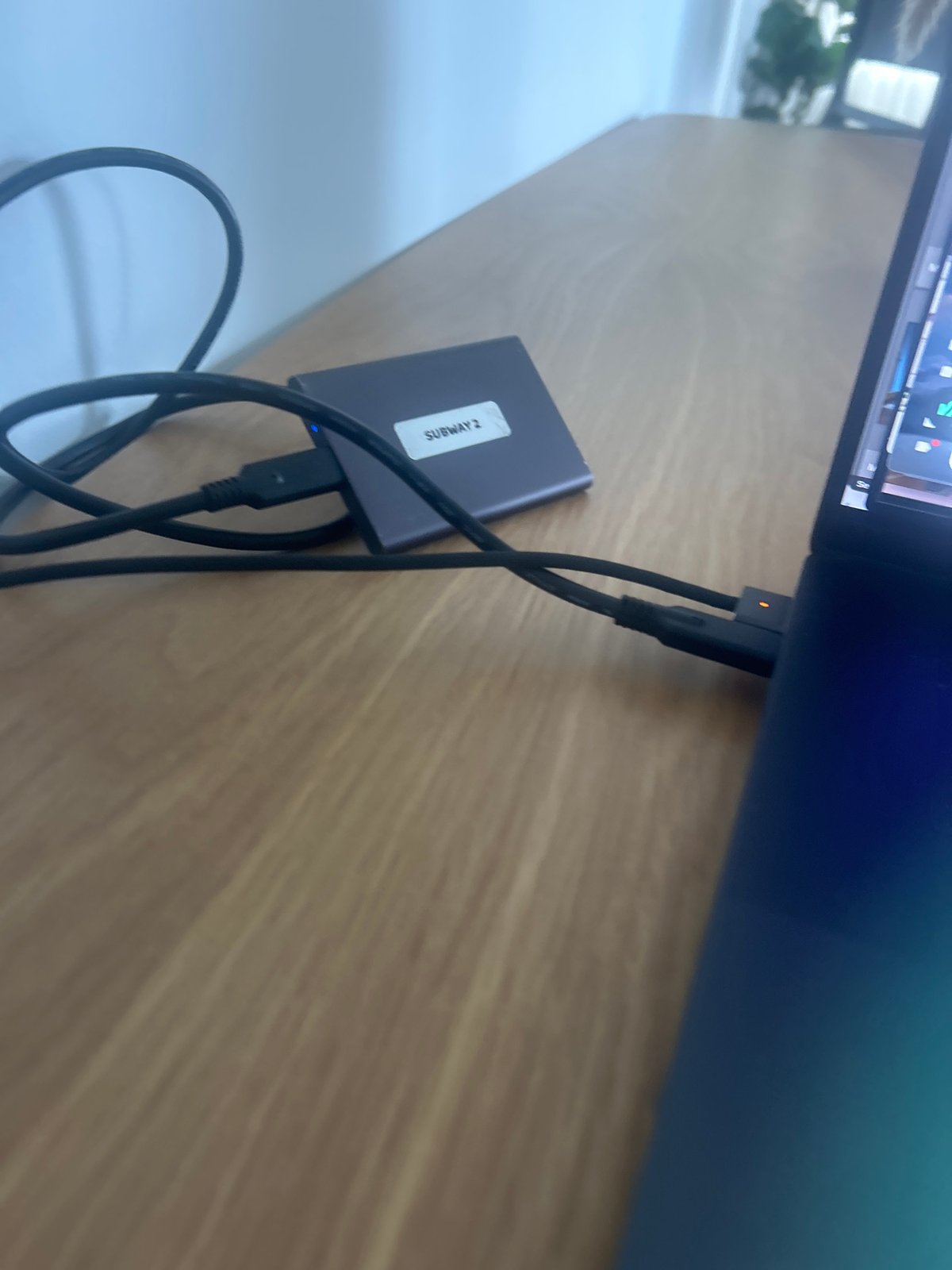 Miami computer user connects external hard drive labeled 'SUBWAY 2'