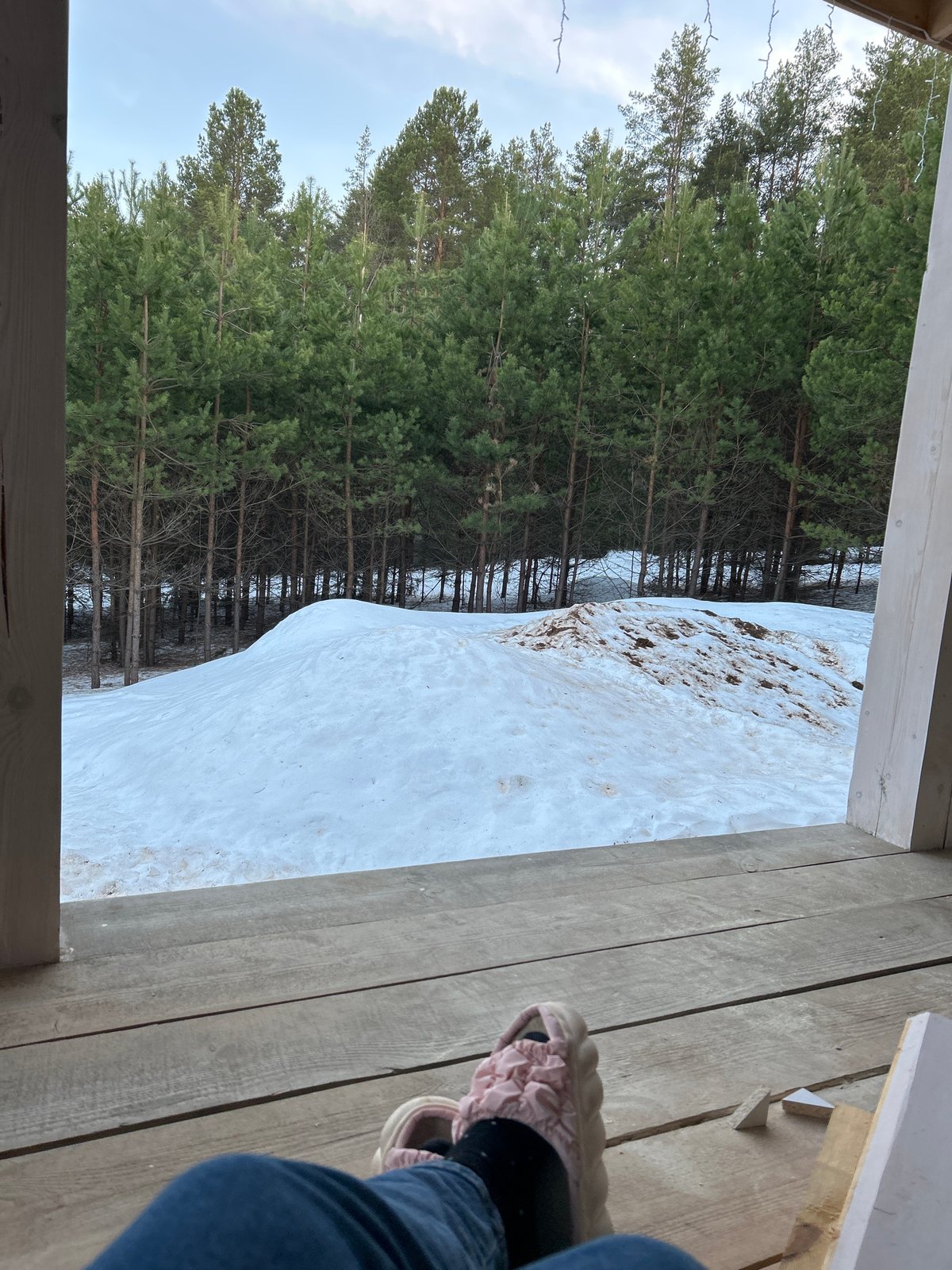 Girl relaxes in hammock on snowy porch in Russia