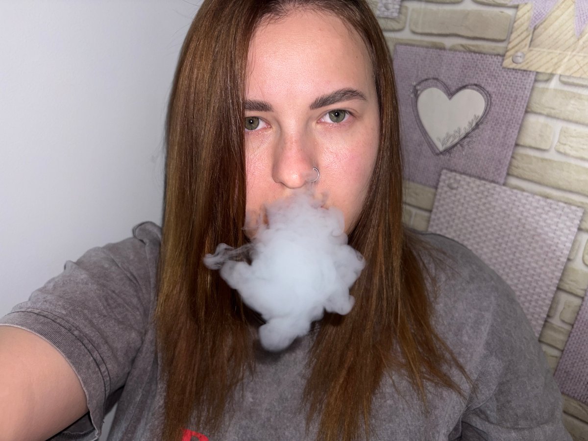Upside-down portrait captured with nose piercing, smoke visible