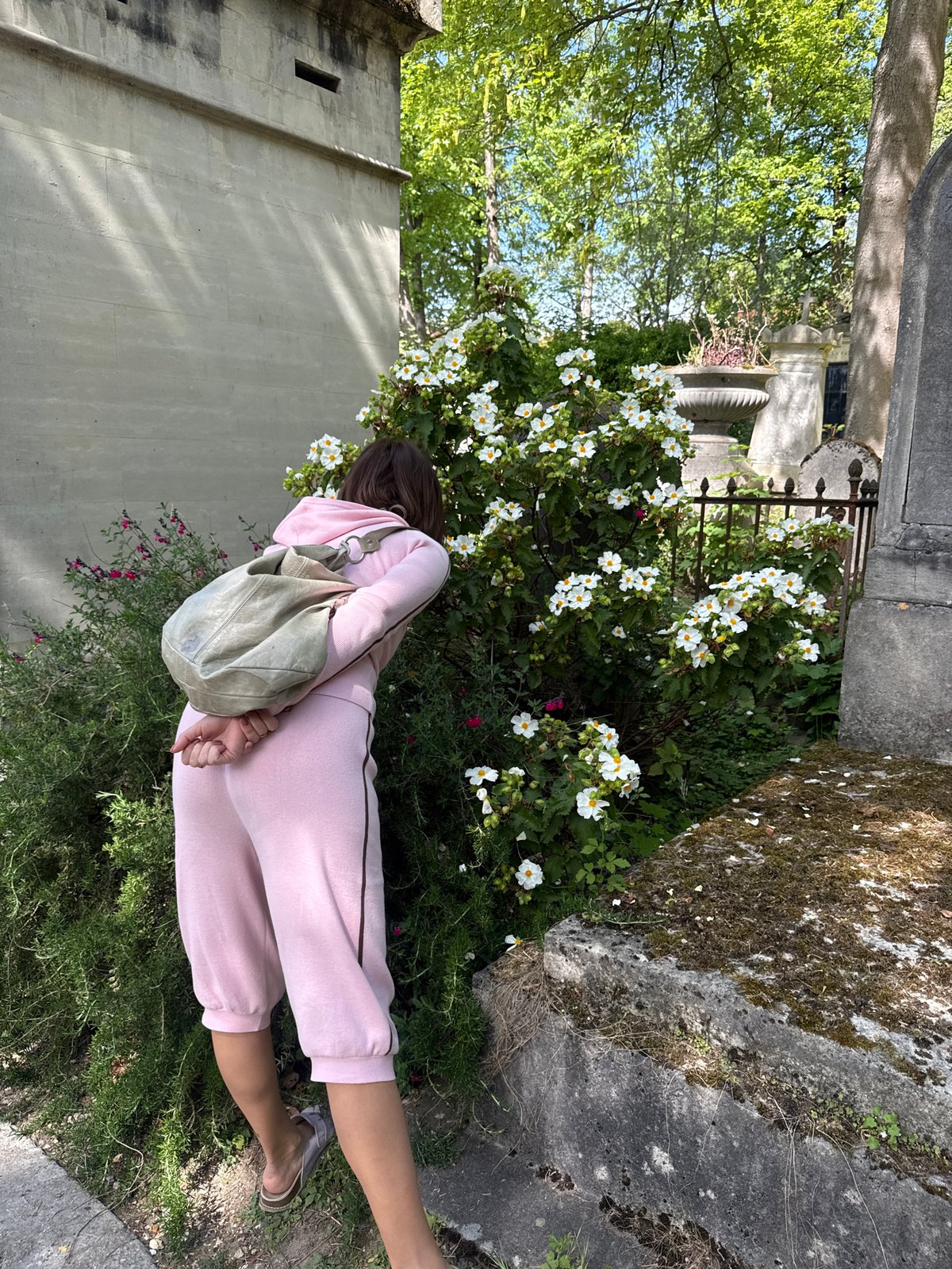 Woman in pink sweatsuit lies in Paris garden