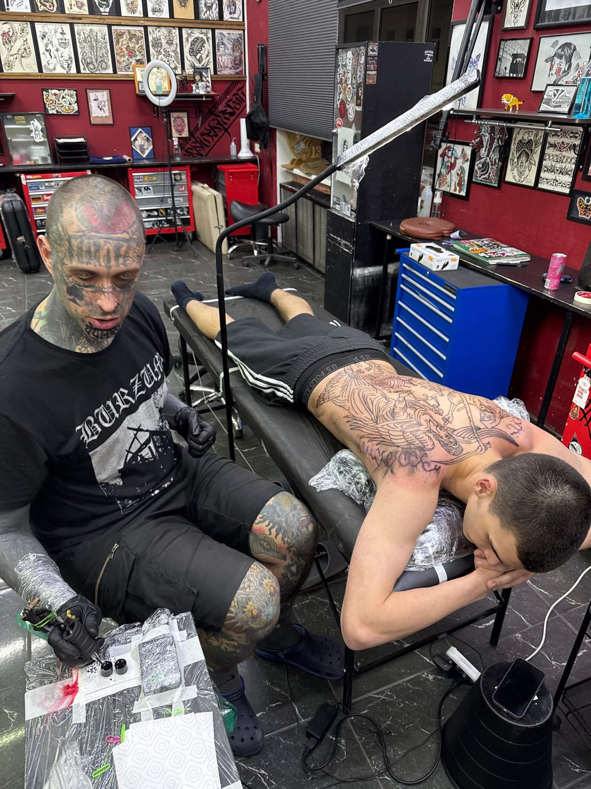 Tattoo artist works on elaborate back piece in Moscow studio