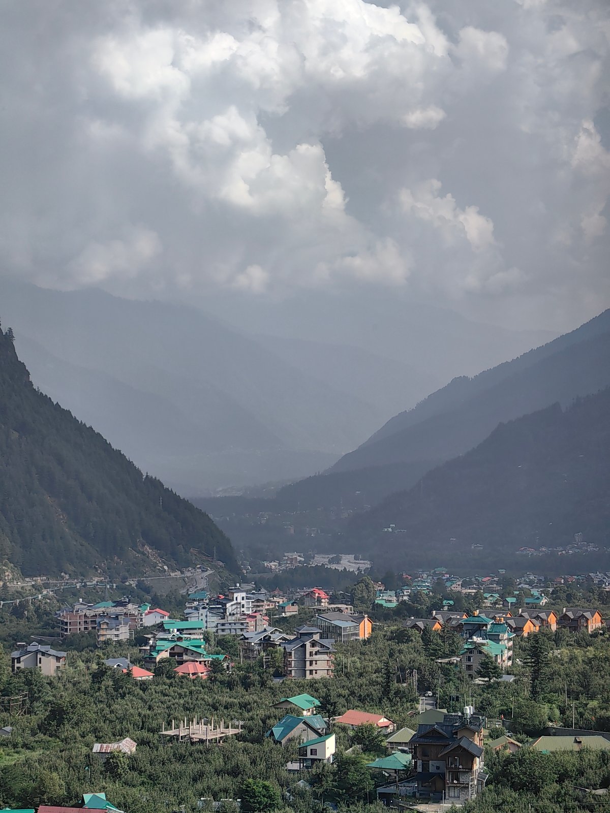 Kullu valley town and mountains under dramatic cloud cover