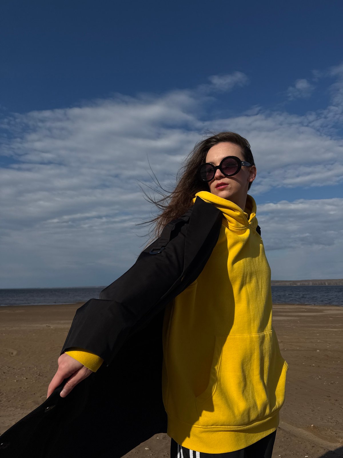 Woman in yellow hoodie enjoys spring day at Russian reservoir