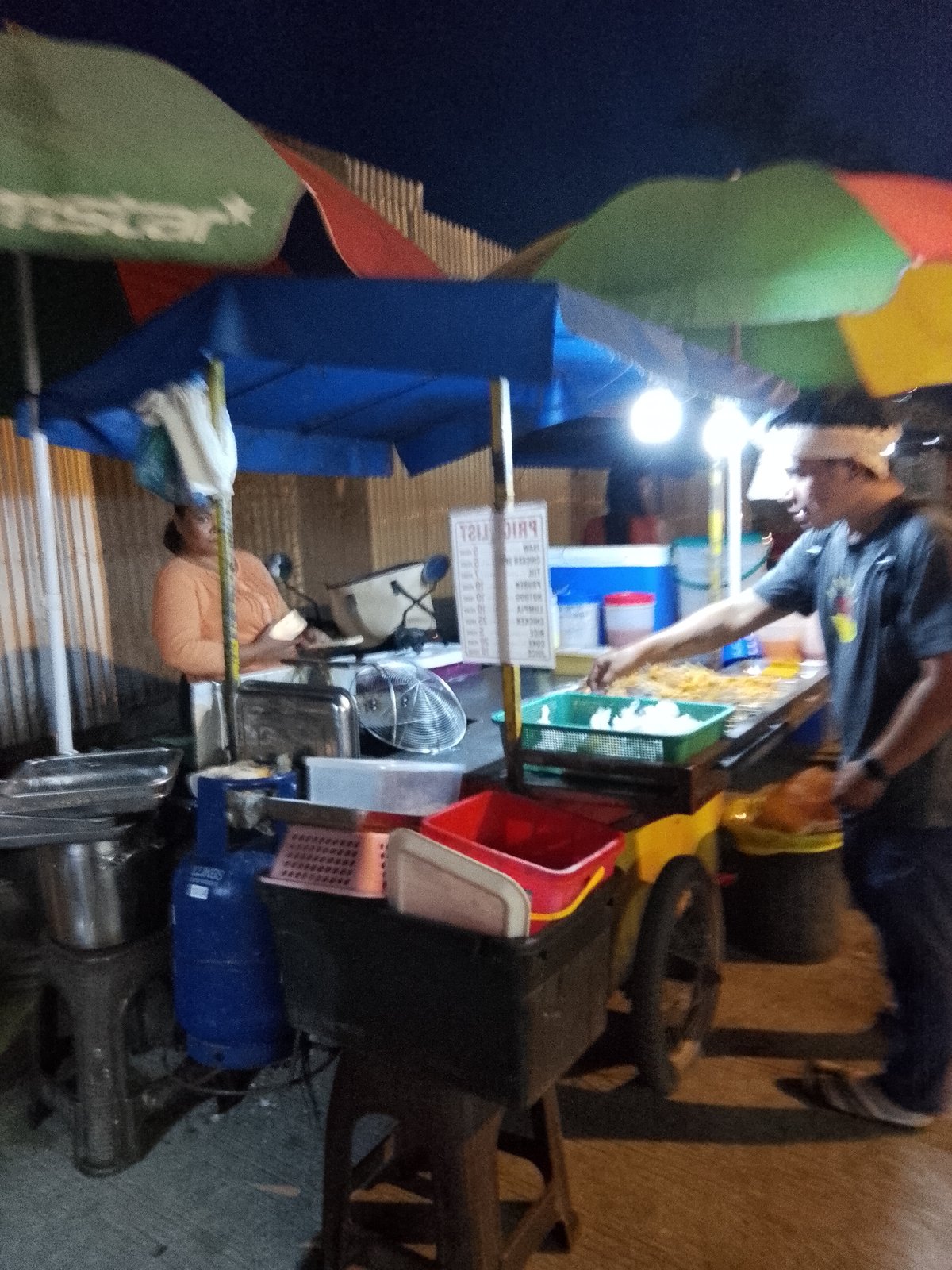 Davao City streets at dusk: traffic, food stalls, and neon glow