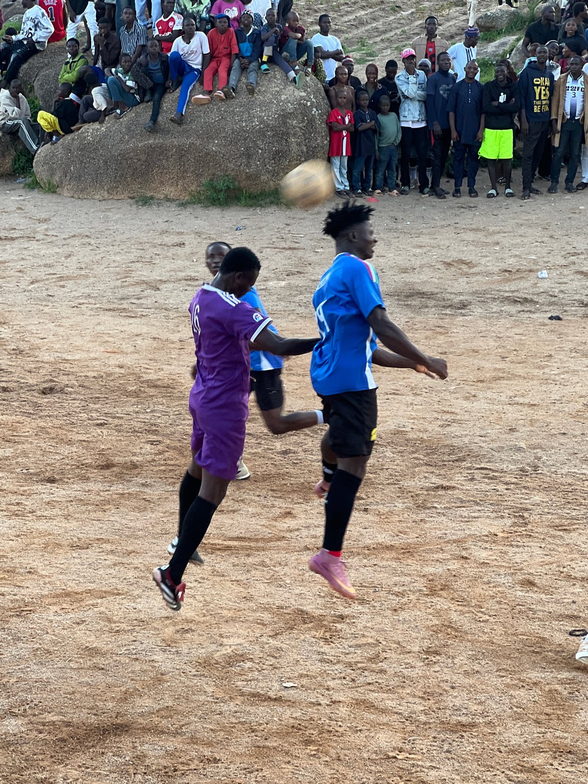 Packed crowd watches local football match on Jos dirt field