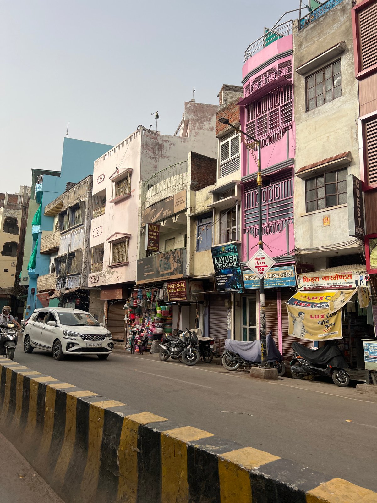 Man tends small street fire in Varanasi commercial district