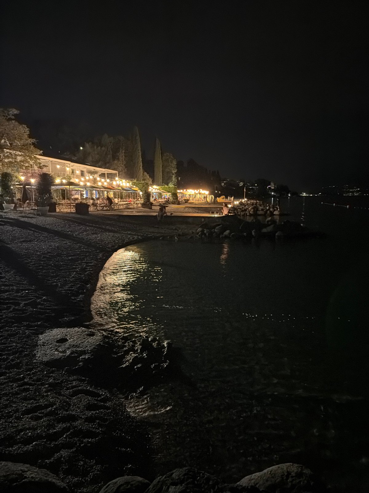 String-lit beachside restaurant on Lake Garda at night