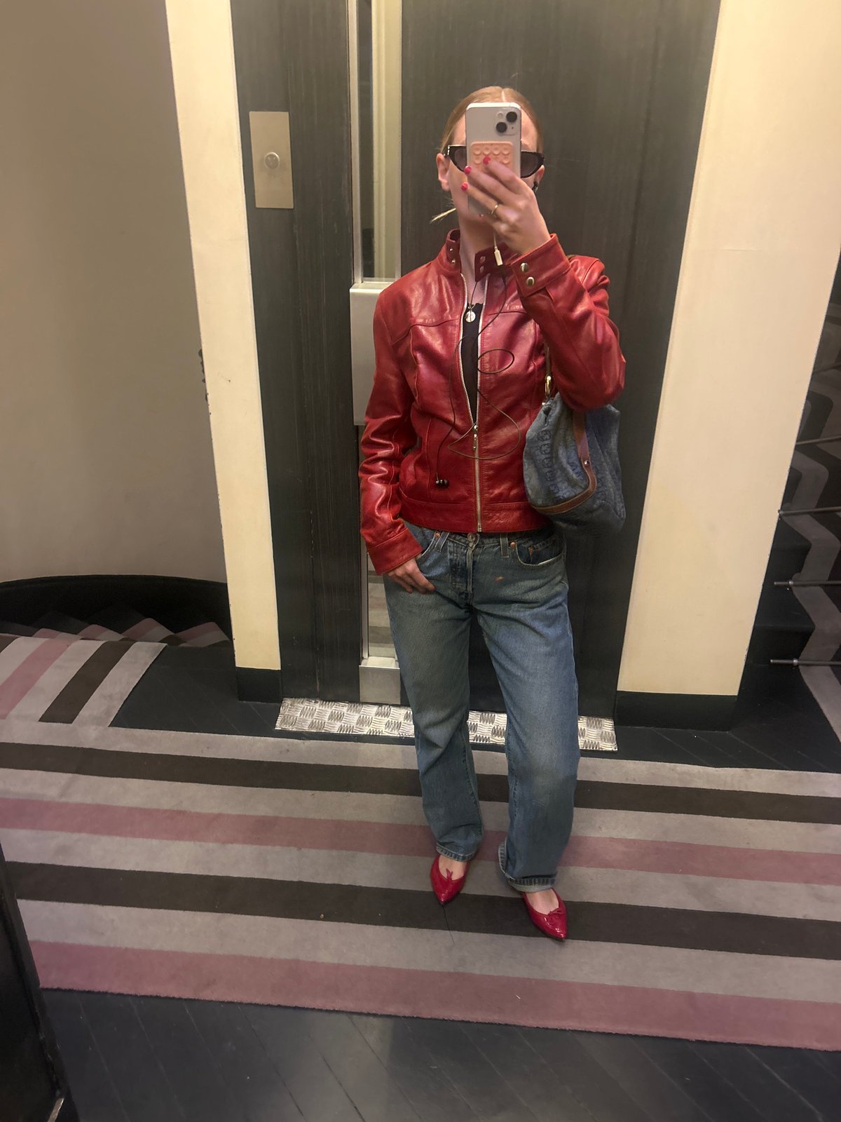 Mirror selfie taken with red jacket and pink-cased iPhone