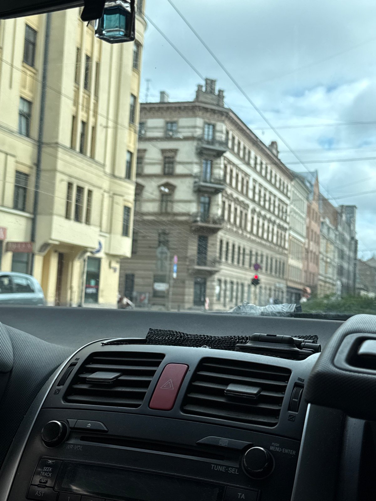 Dashboard-framed view of Riga streets through a car windshield
