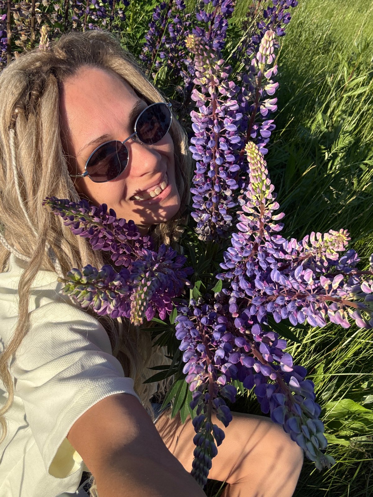 Woman photographed smiling in flower field during outdoor session