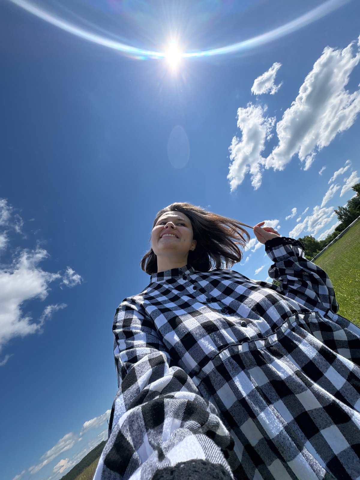 Woman documents countryside flower-picking session in pastoral setting