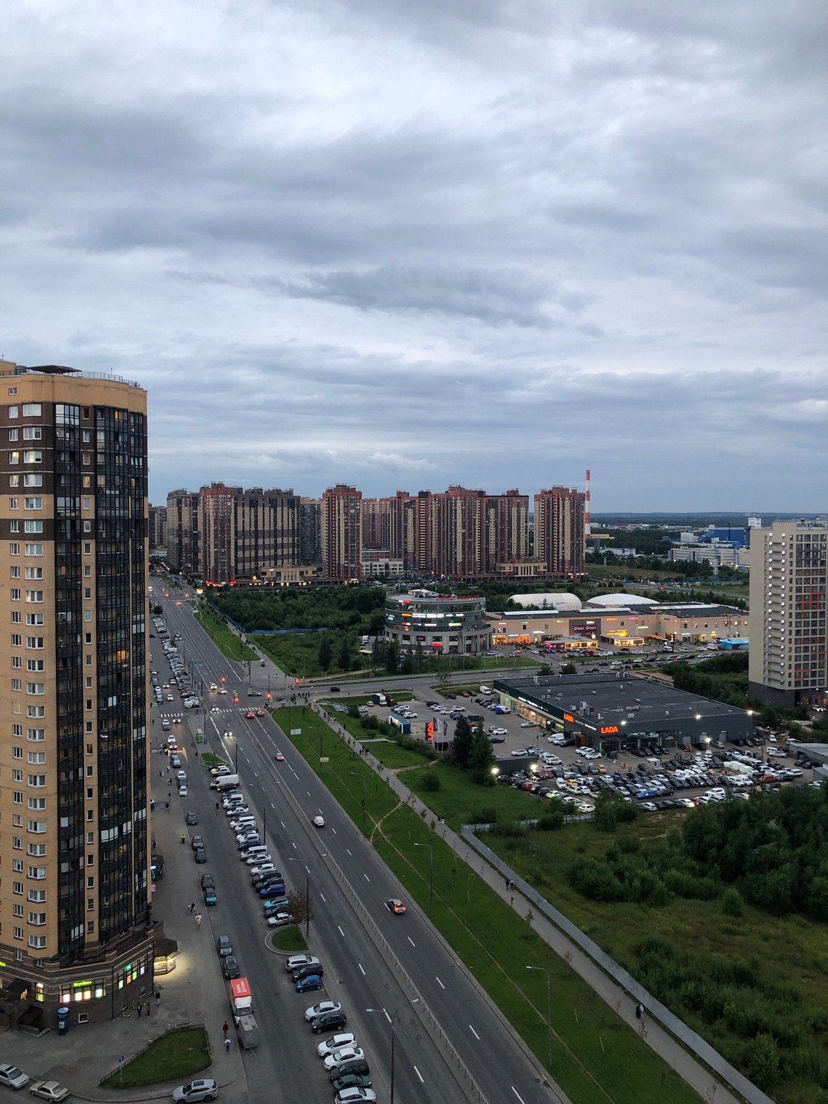 Aerial sweep over a cloudy Russian urban district with Lada dealership