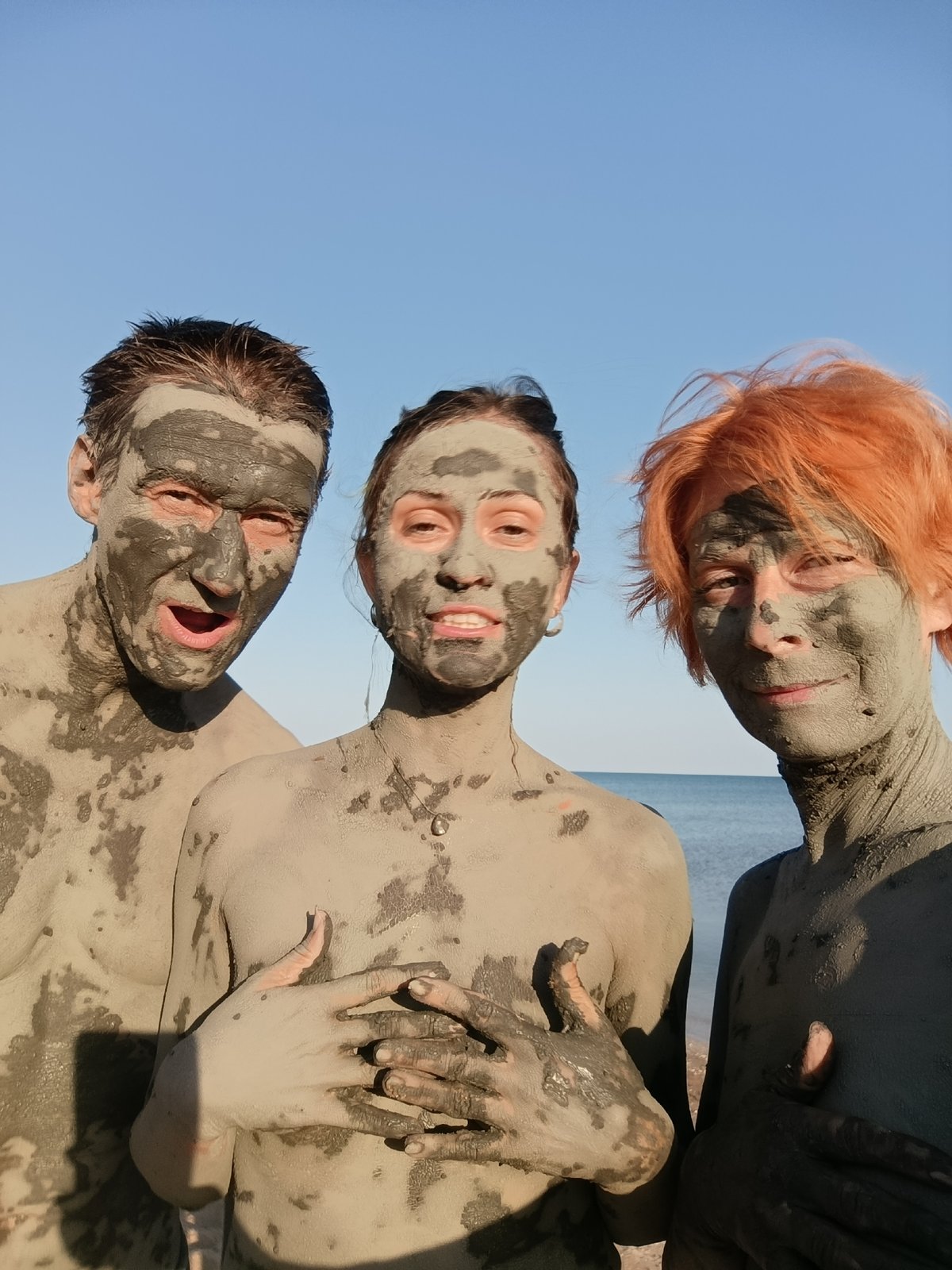 Mud-covered group selfie by the water in Kuchugury