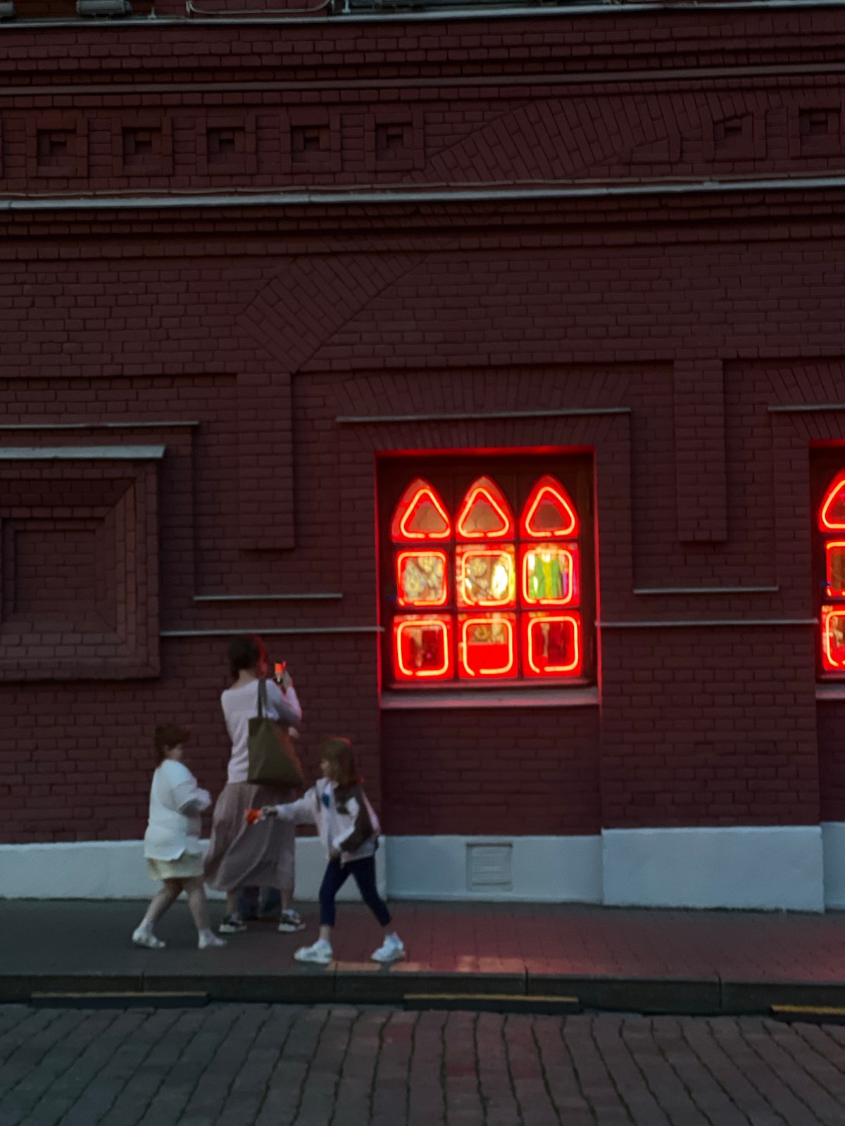 Neon-lit building draws pedestrians in Khimki, Russia