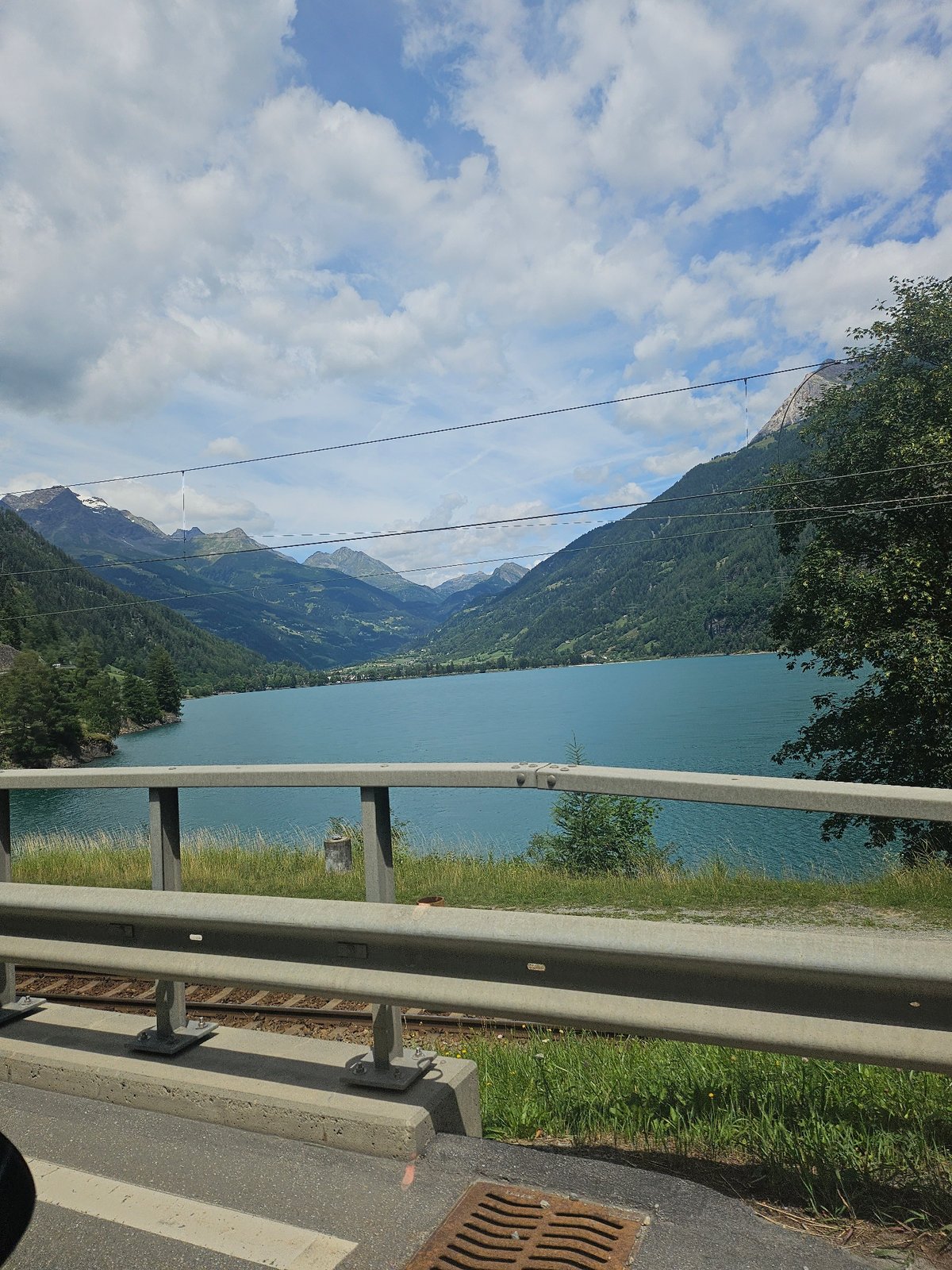 Trackside views of a turquoise alpine lake in Le Prese