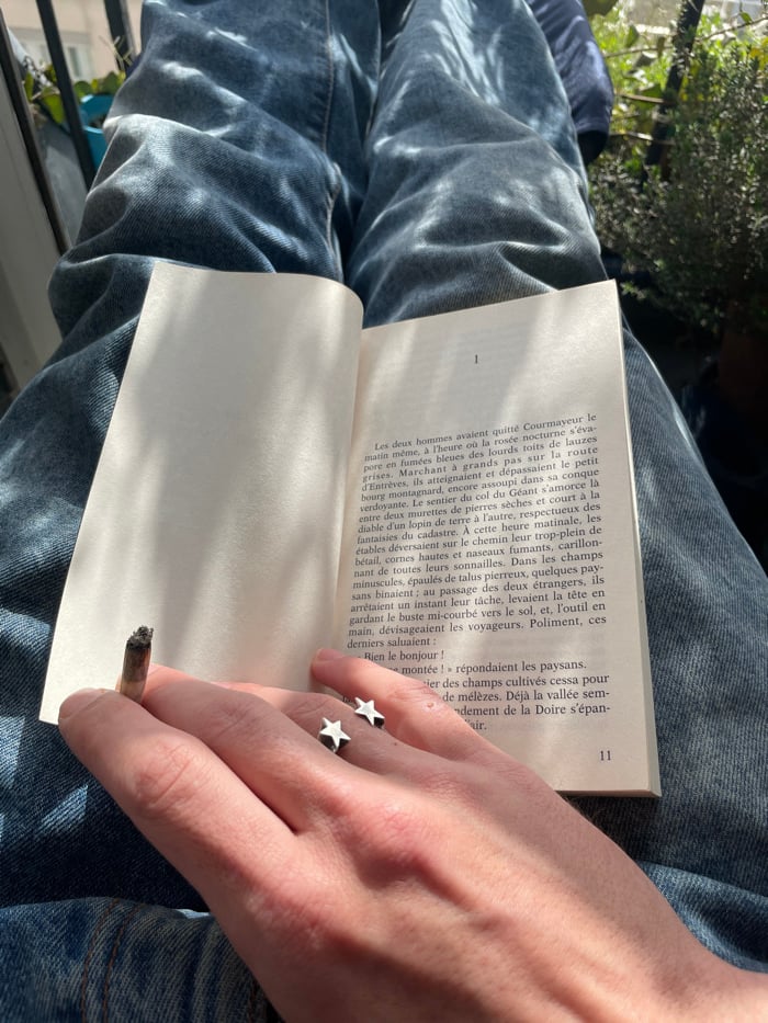 Person relaxes on sunny Paris balcony in blue jeans