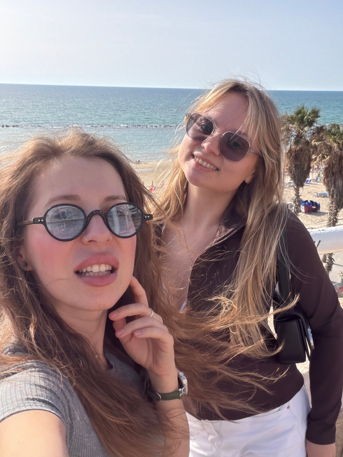 Women take beachside selfies on Bat Yam balcony