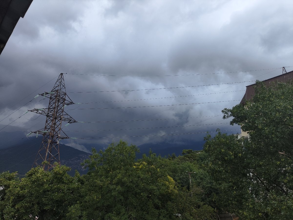 Storm clouds gather while a cat naps peacefully inside near Massandra