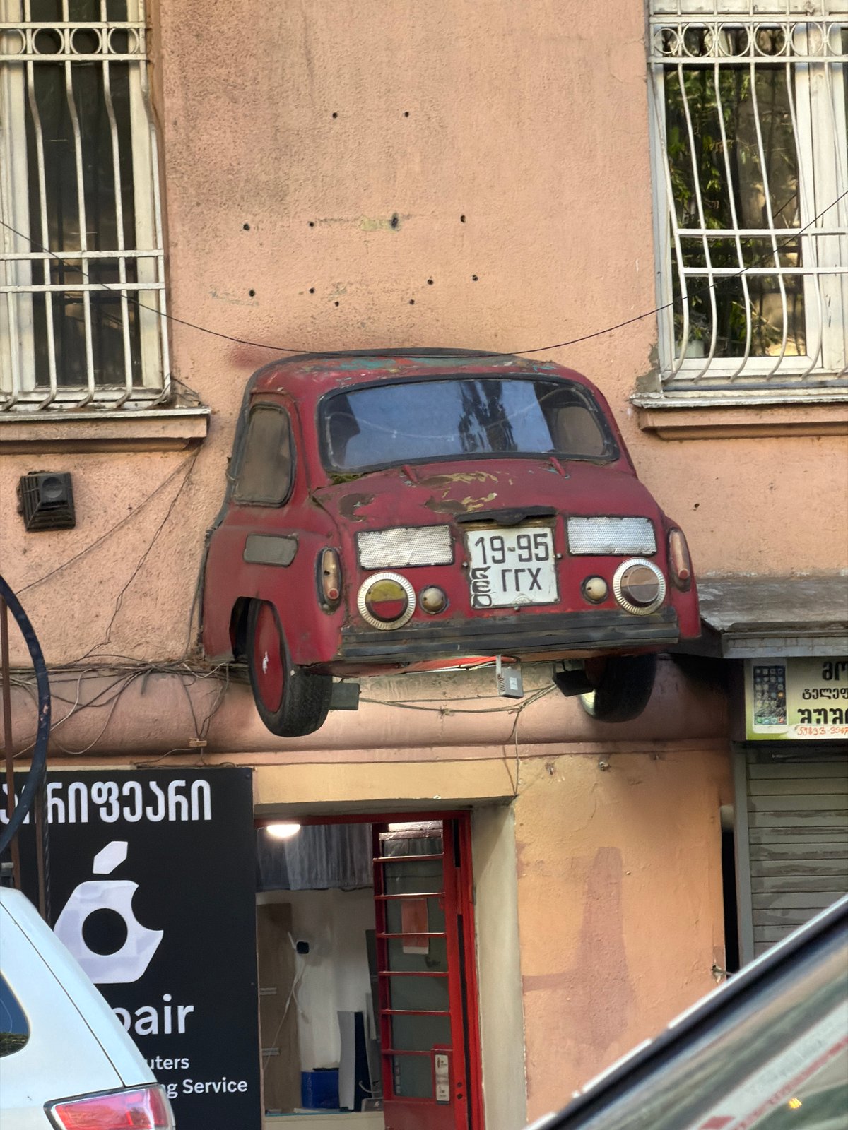 Vintage Soviet car mounted vertically on Tbilisi building wall