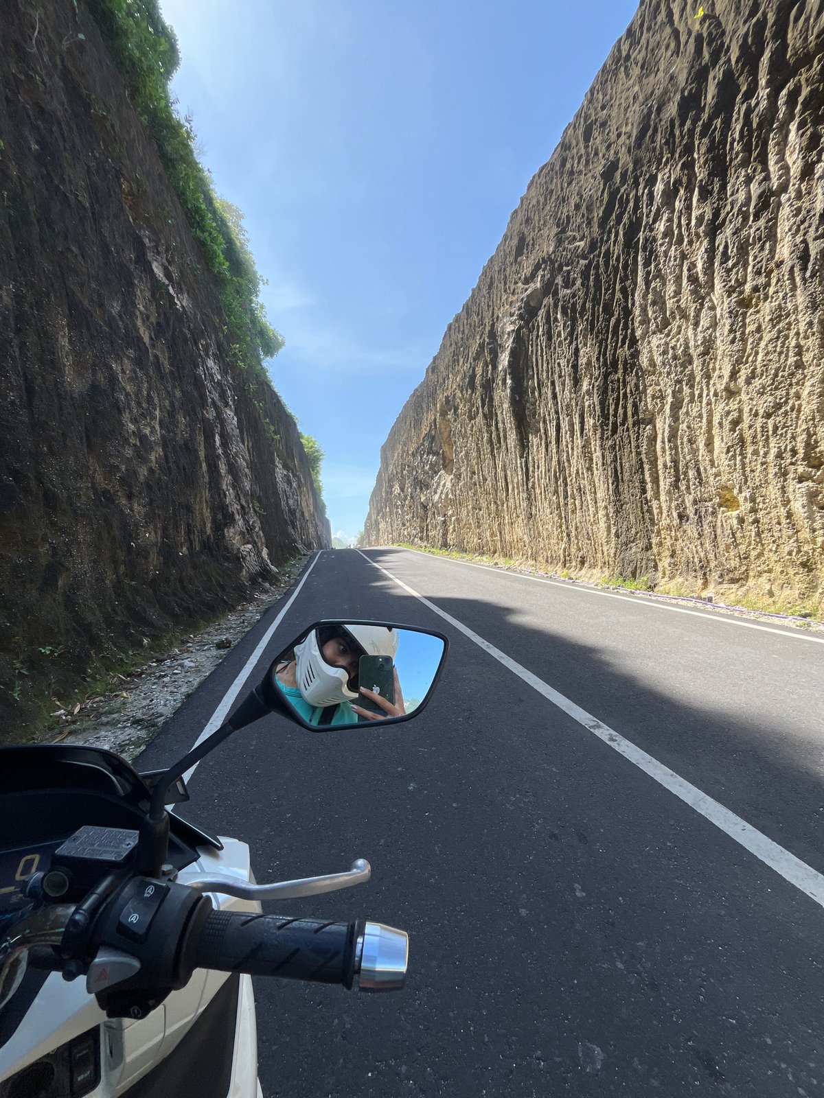 Motorcyclist Takes Selfie on Cliff-Lined Road in Kuta Selatan