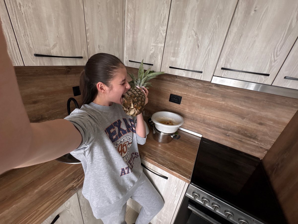 Woman holds pineapple in Bulgarian kitchen
