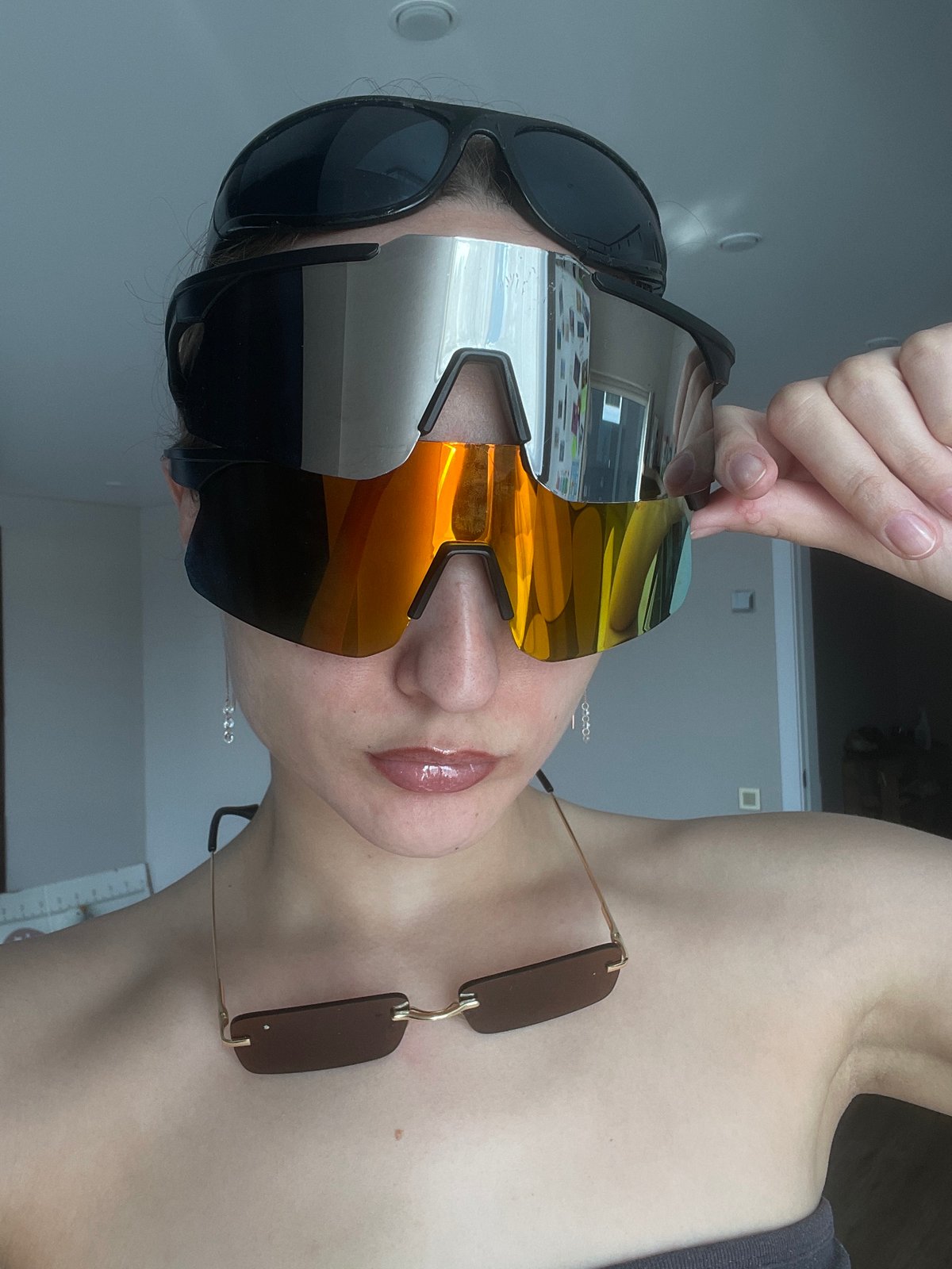 Woman wears multiple sunglasses indoors in Russian village