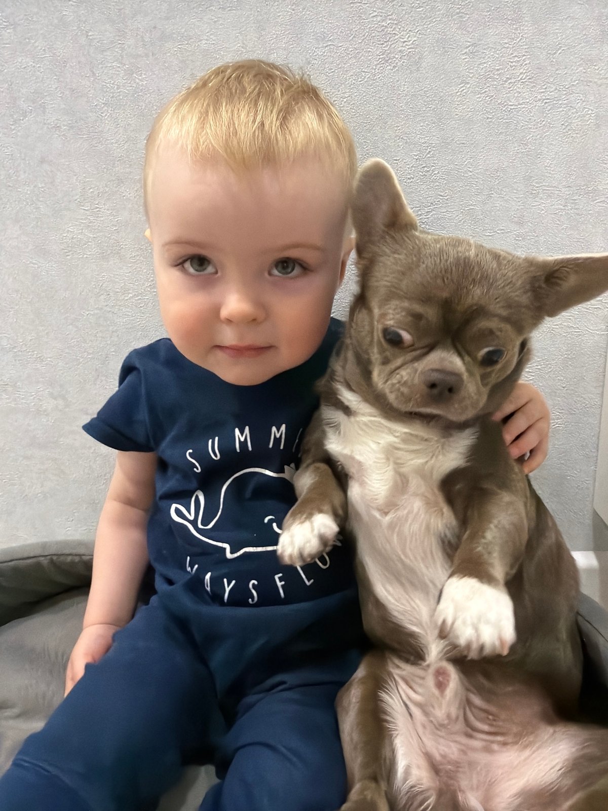 Child and small dog share tender moment in Votkinsk