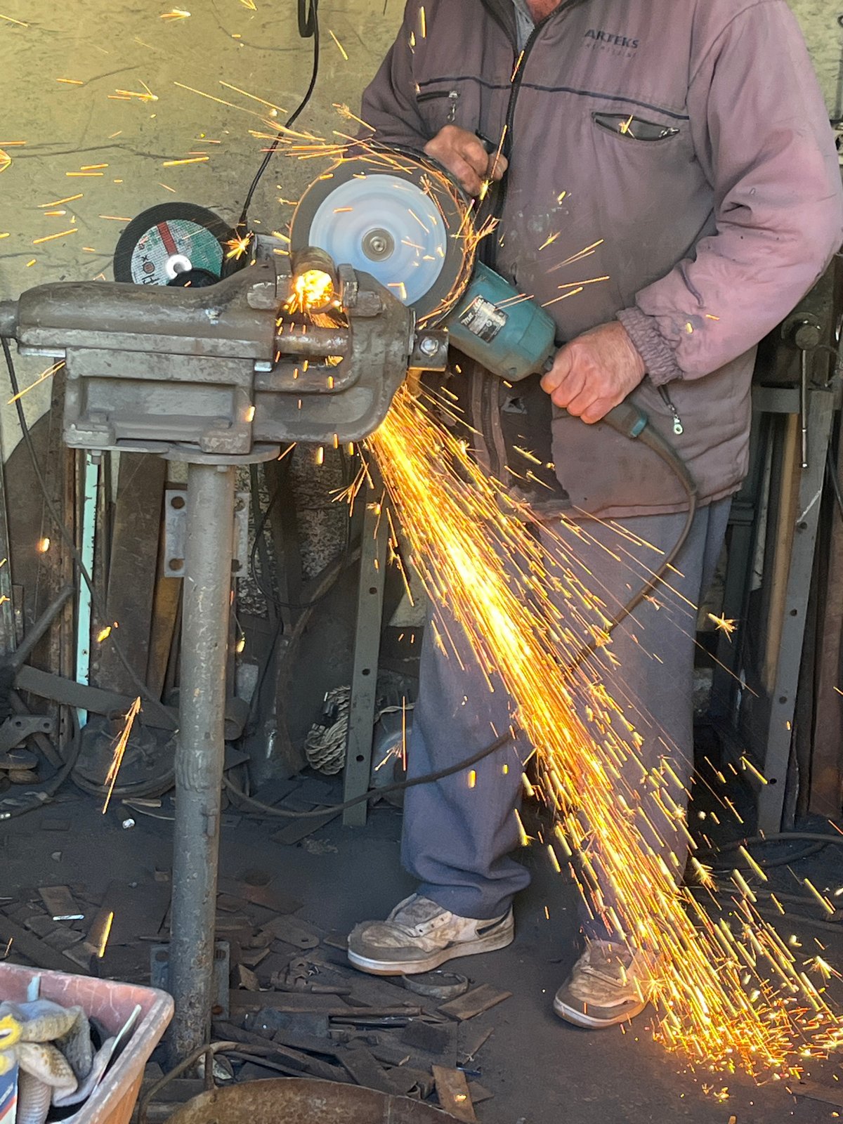 Metalworker performs grinding, welding operations in workshop session
