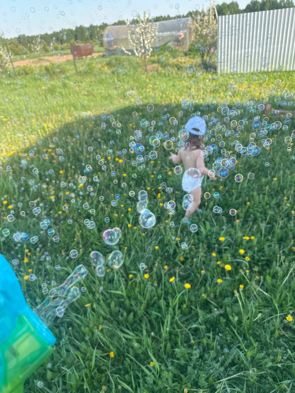 Child plays with bubble gun in Russian field